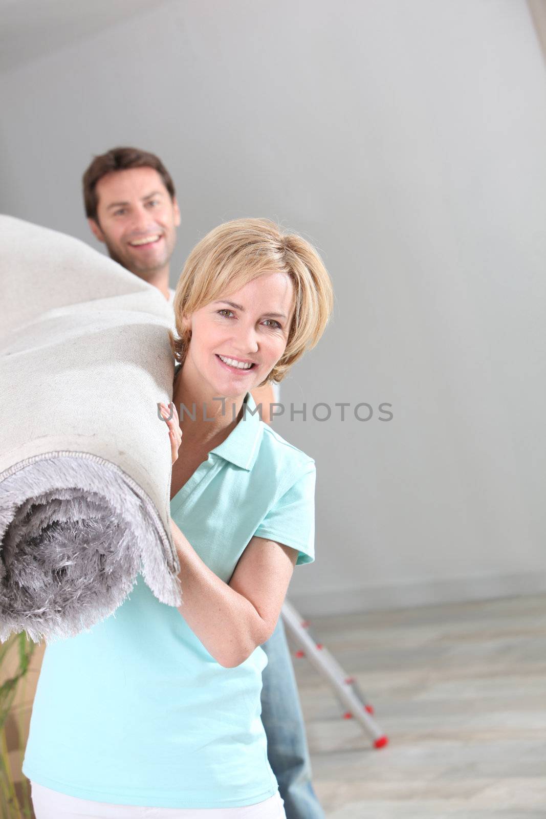 Couple carrying rug by phovoir
