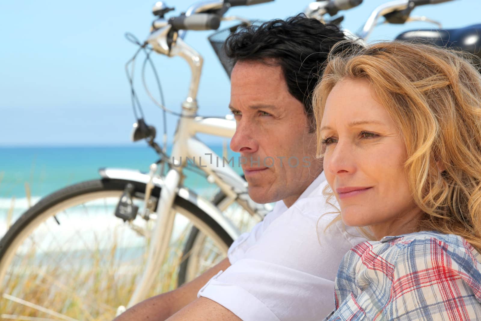 Couple with bicycles by the coast by phovoir