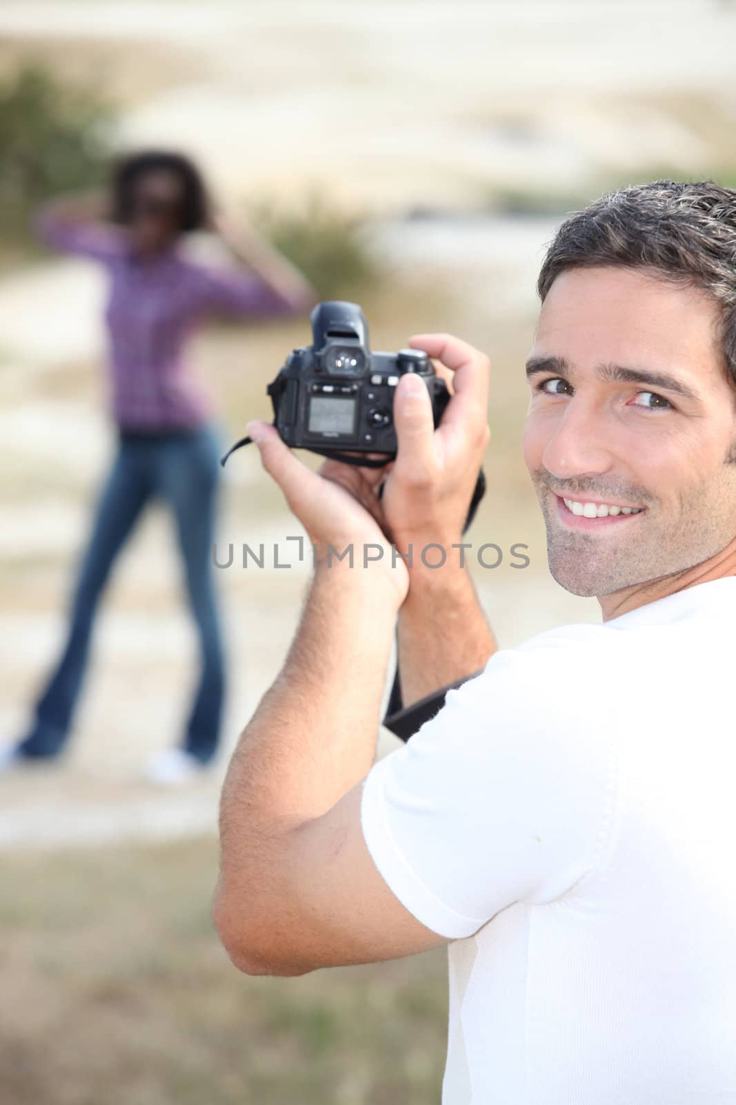 Man taking a photo of his girlfriend by phovoir