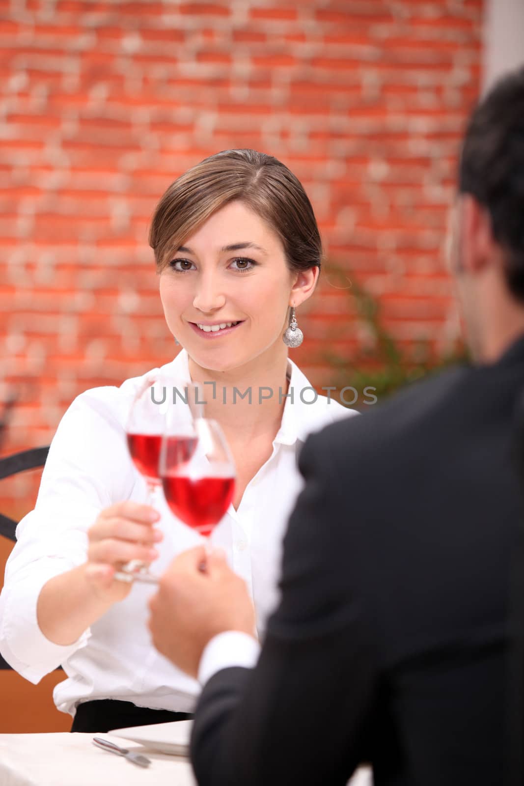 Couple toasting with rose wine by phovoir