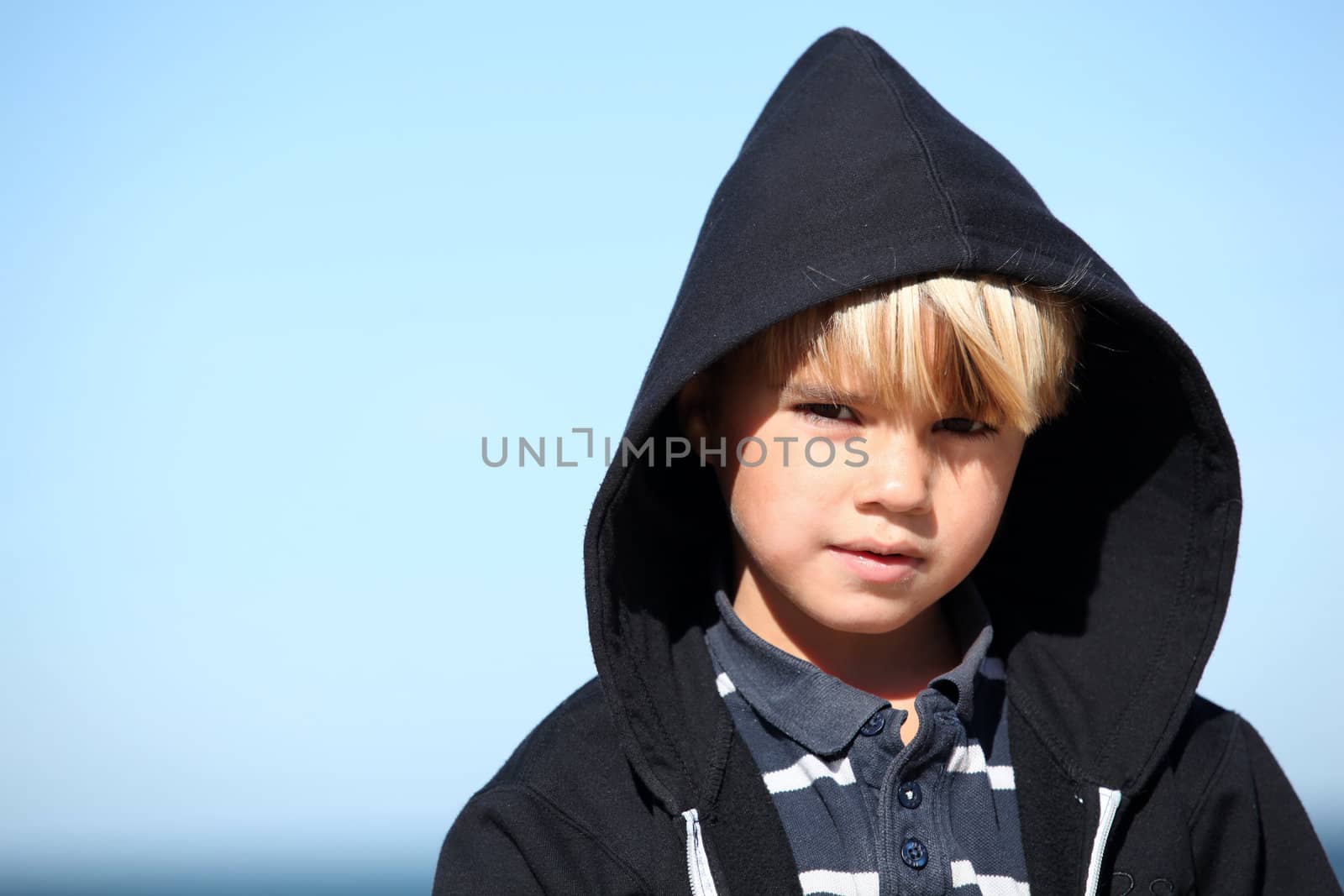 Little boy against a blue sky by phovoir