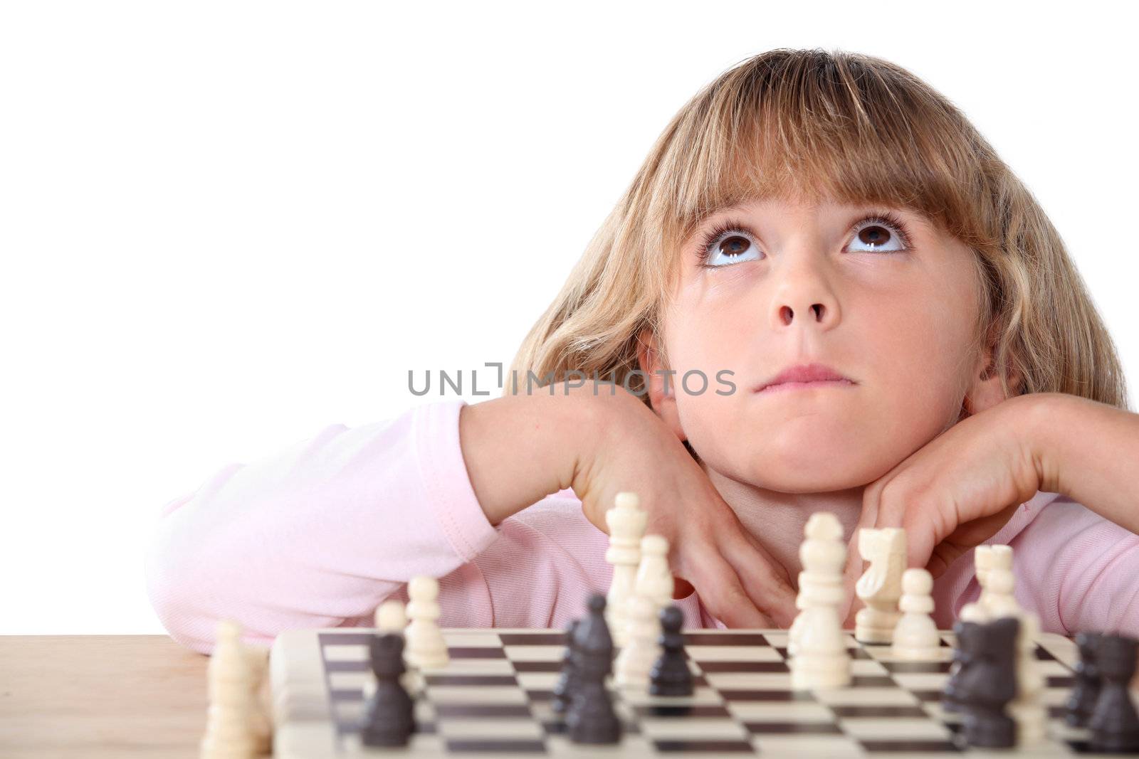Little girl playing chess by phovoir