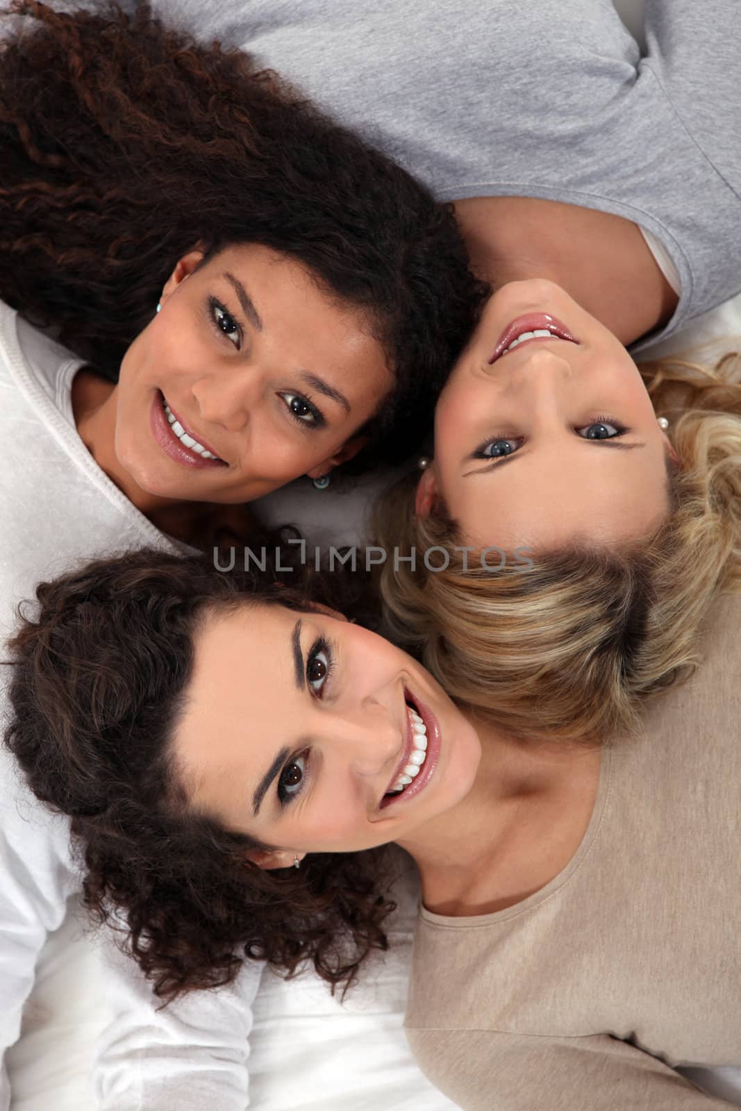 Three female friends laying together