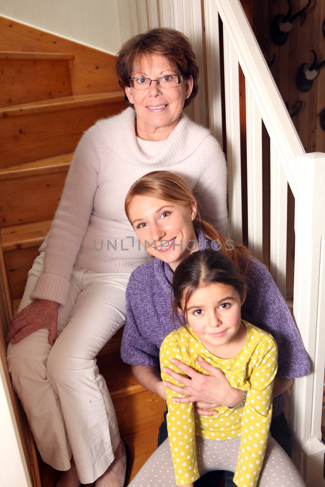 grandmother, mother, and daughter sitting on stairs