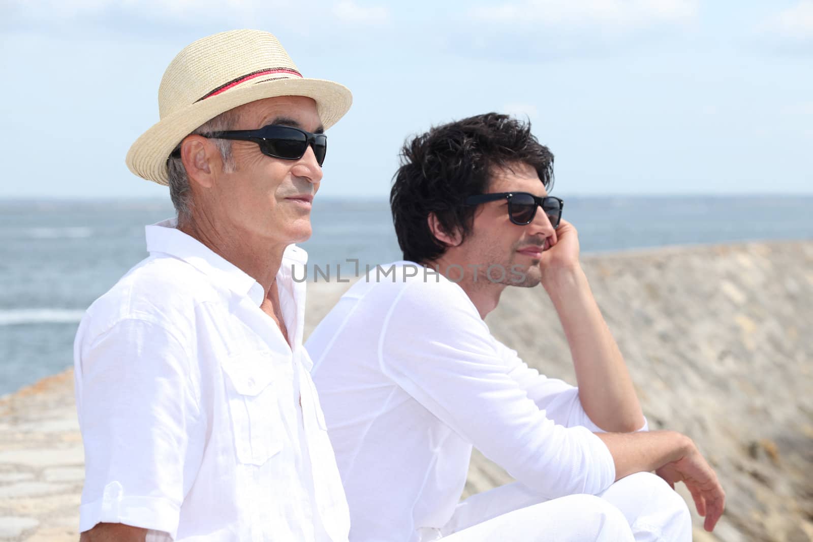 A father and his son looking at the sea.