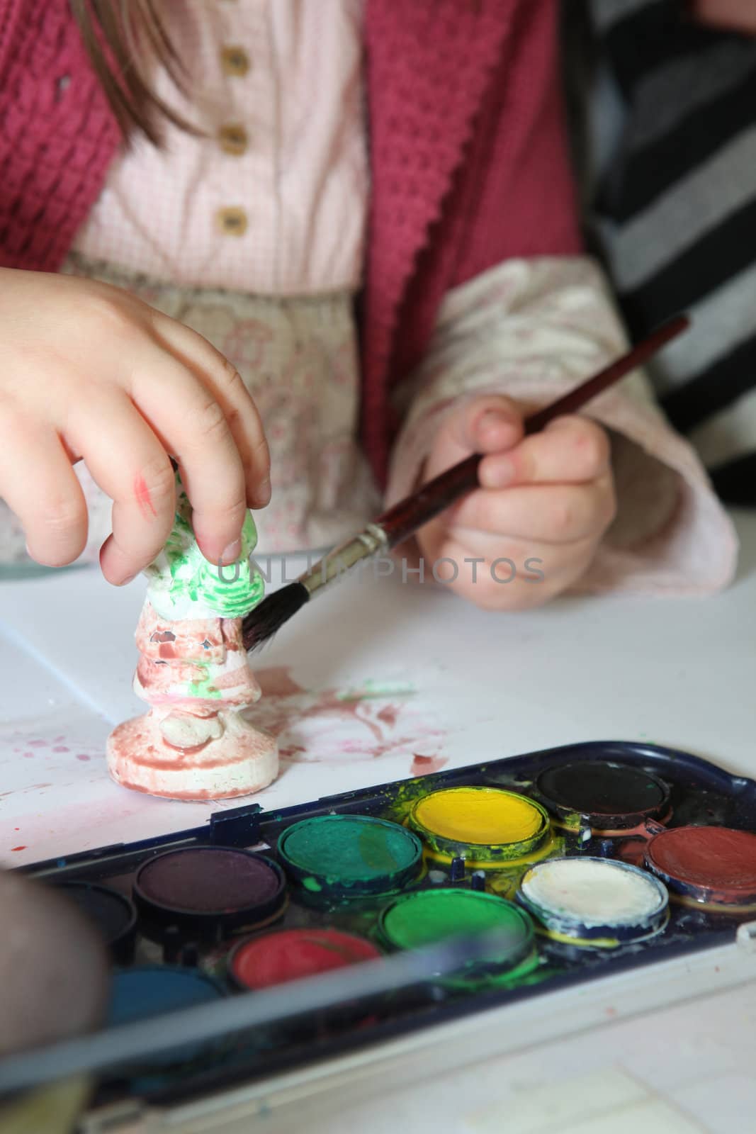 Child painting a plaster figurine
