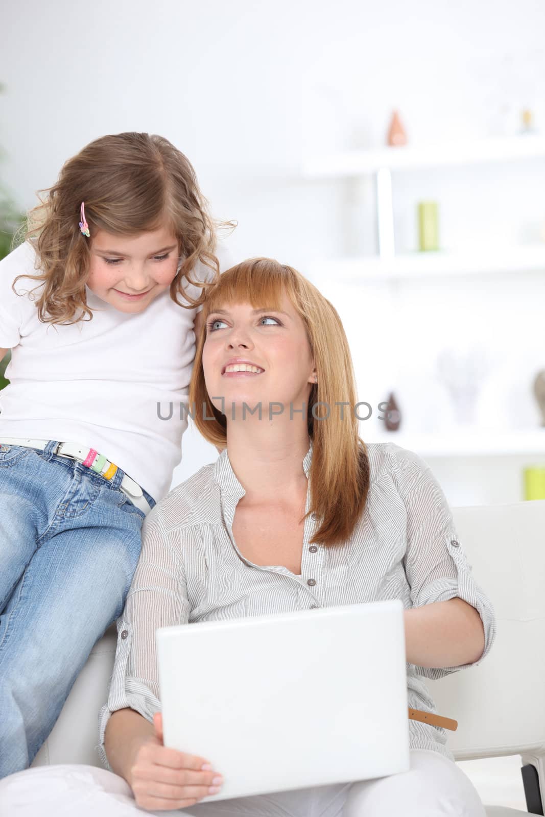 Curious girl looking at her mother's laptop