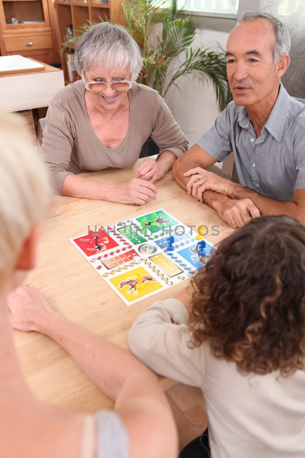 Family playing board game together by phovoir