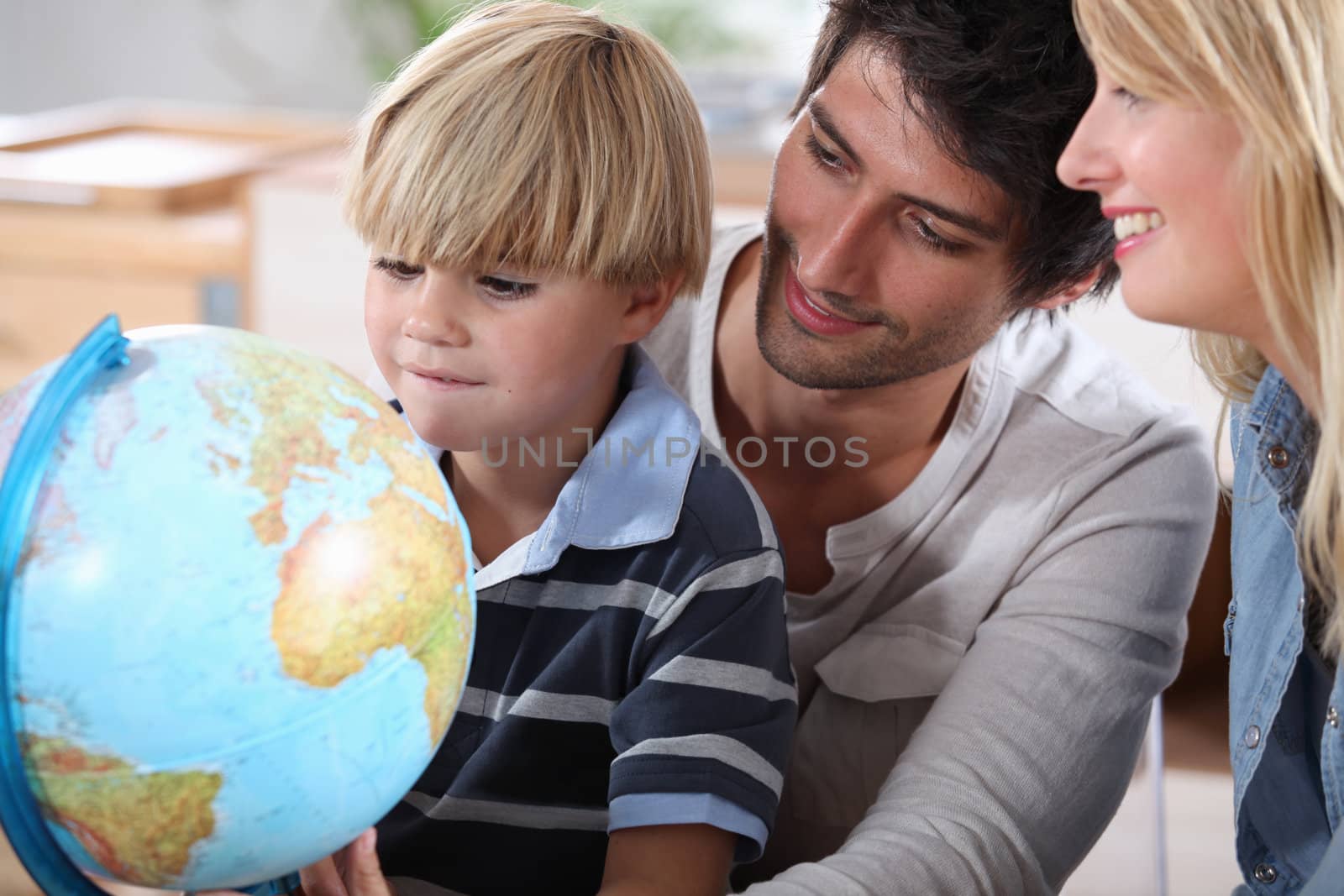 Little boy learning about the world with the help of his parents by phovoir