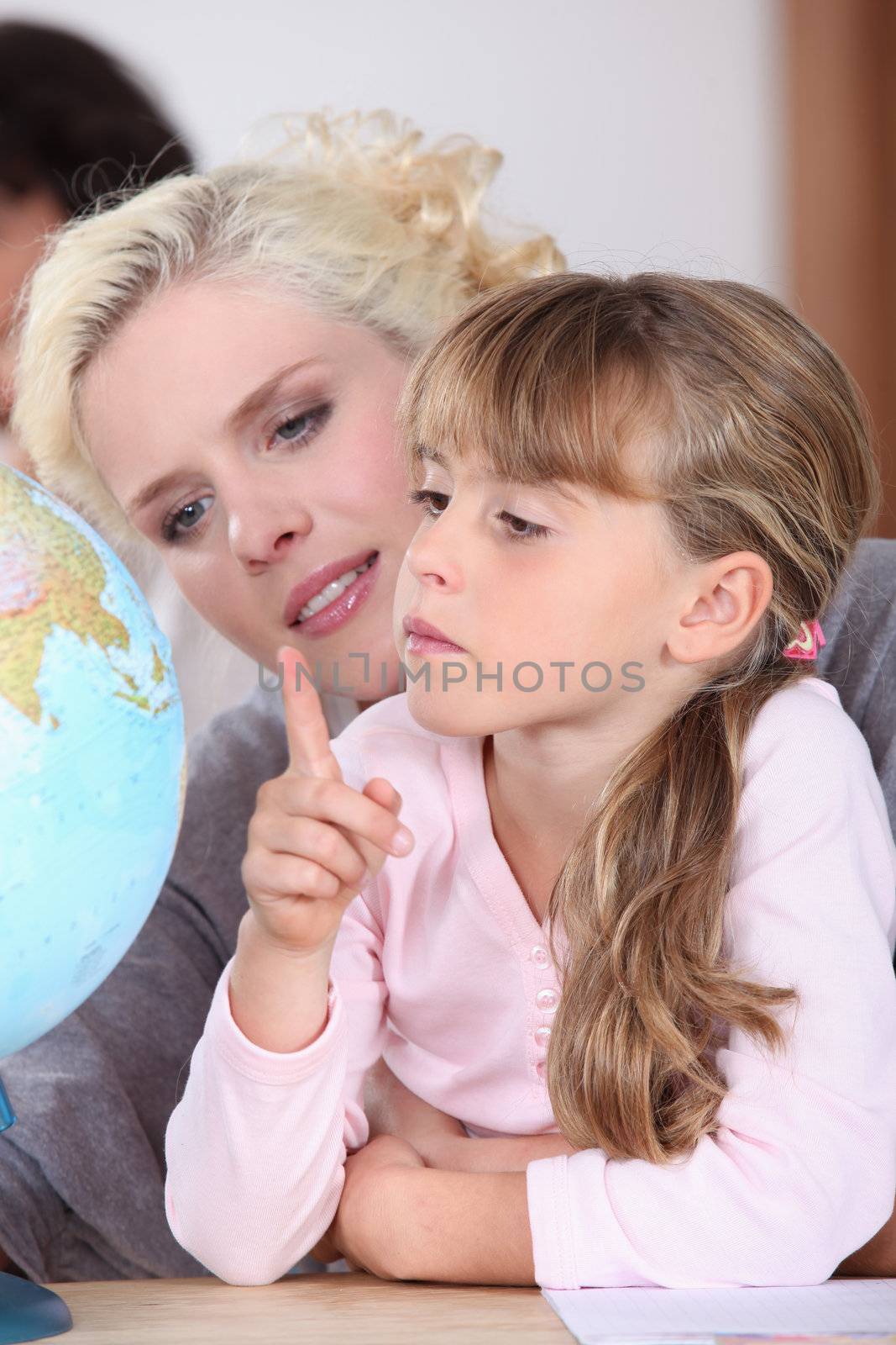 mother and daughter looking at a globe light