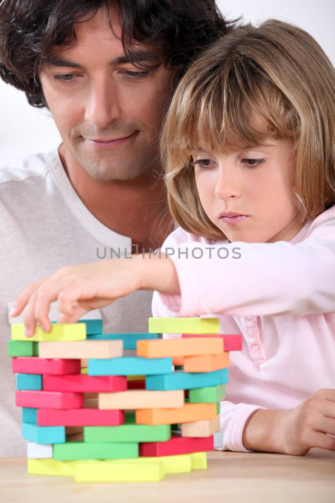 Father and daughter building a tower of blocks