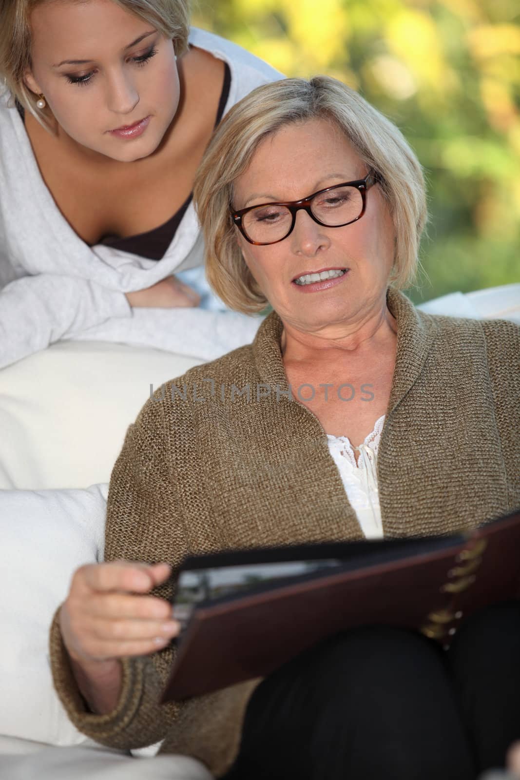 grandmother and granddaughter skimming through family album