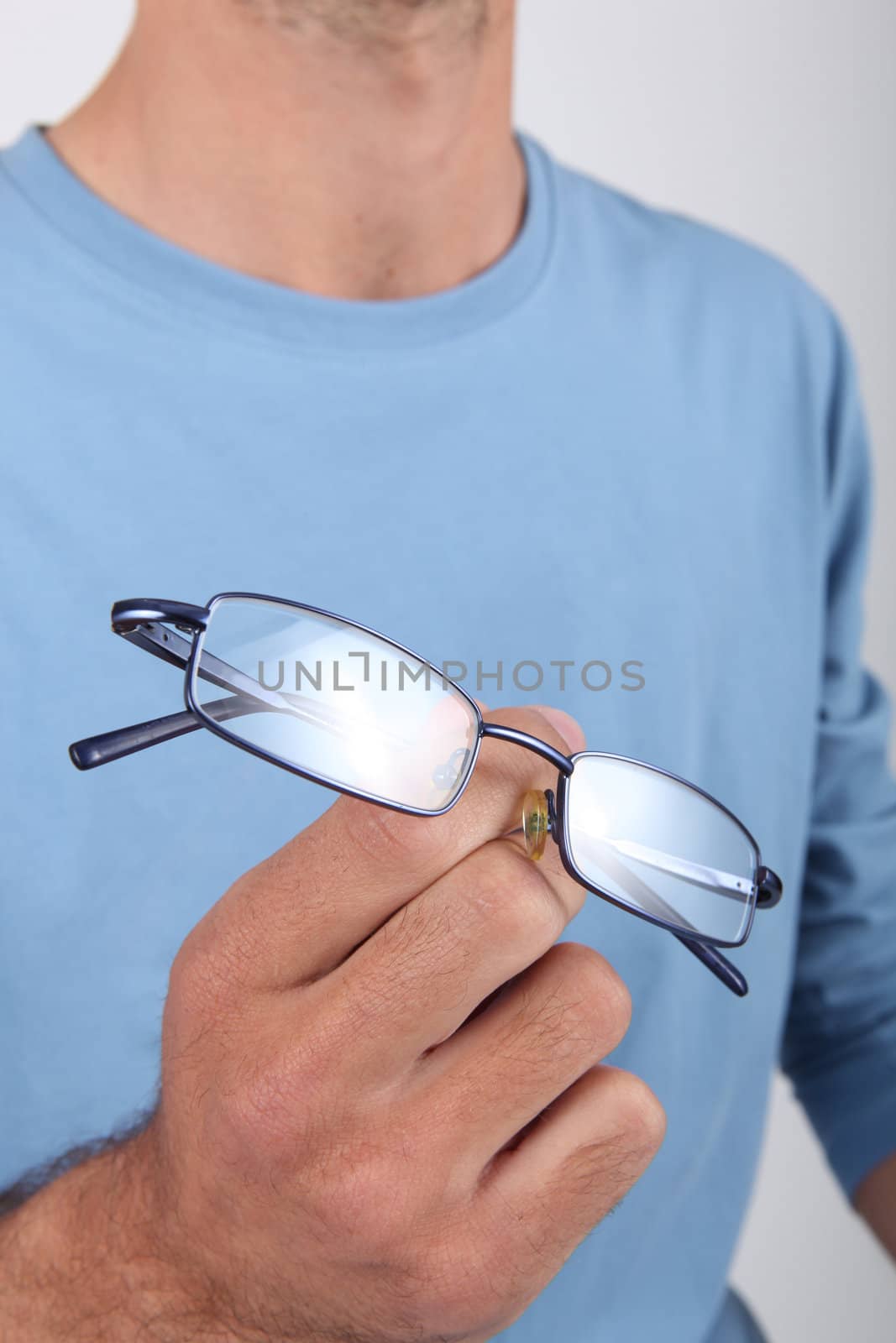 Casually dressed man holding his glasses in his hands by phovoir