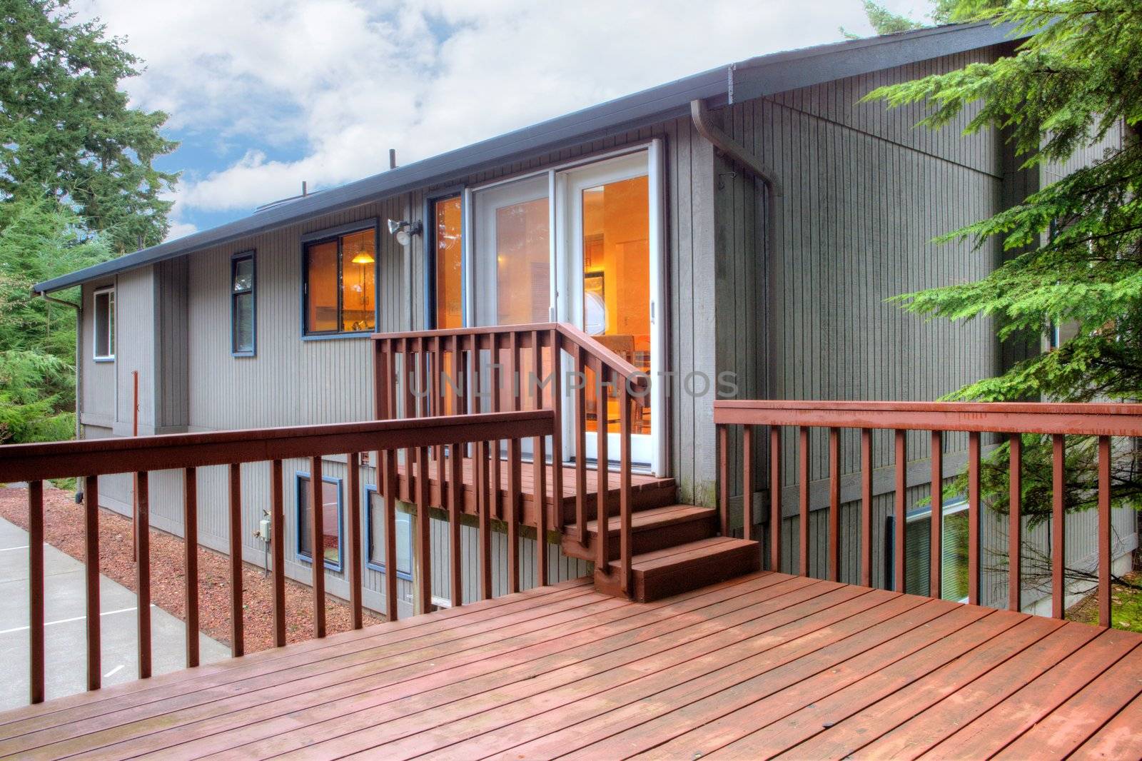 Back of the brown house with simple deck.