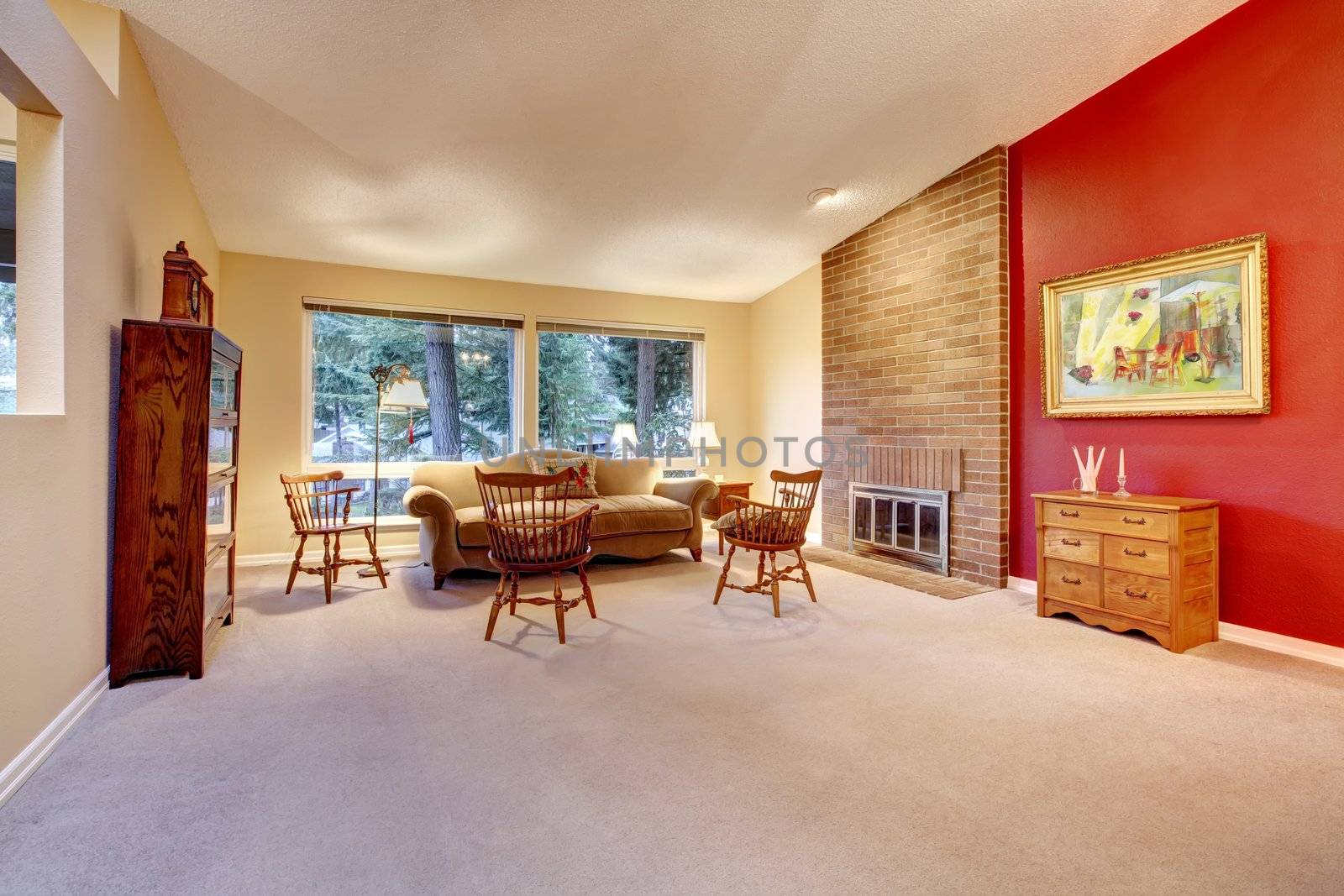 Large living room with red wall and brick fireplace.