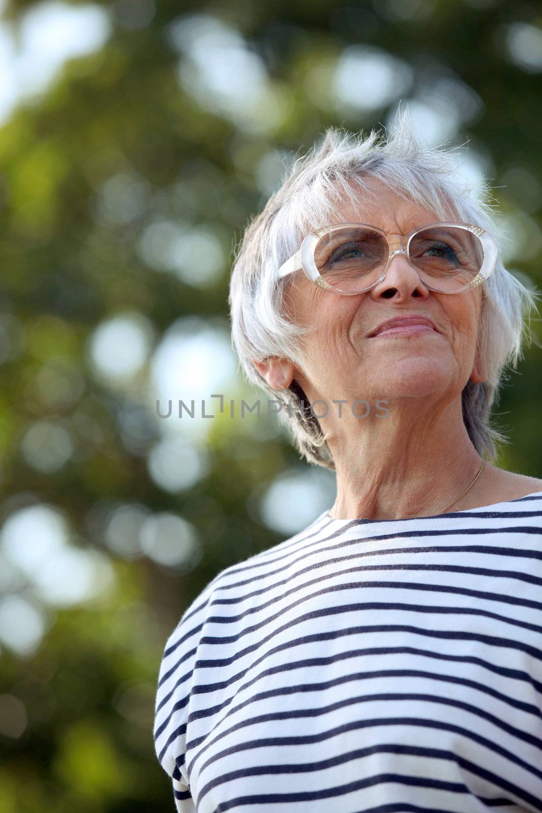 senior woman walking in the park by phovoir