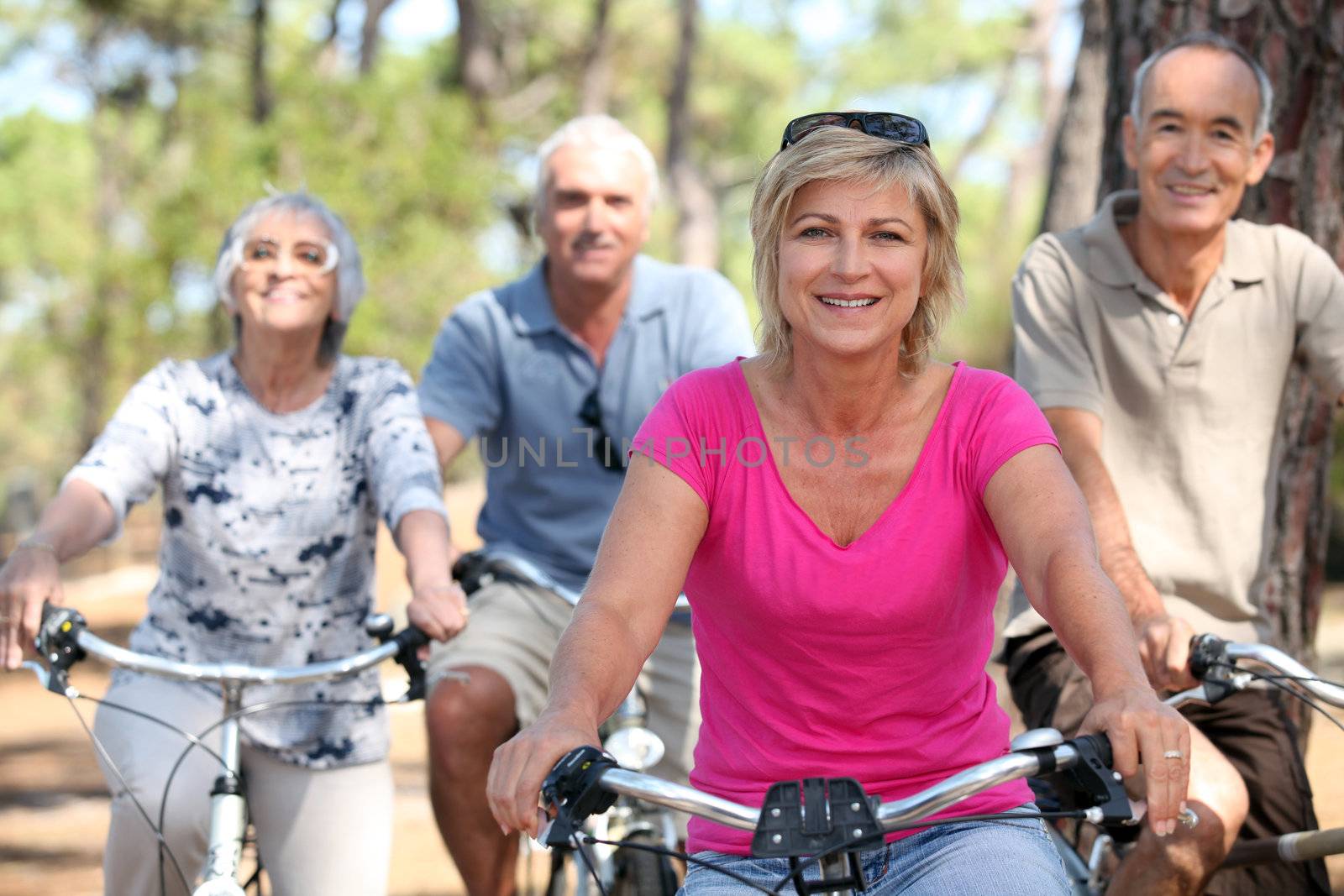 seniors riding bicycles in the park by phovoir