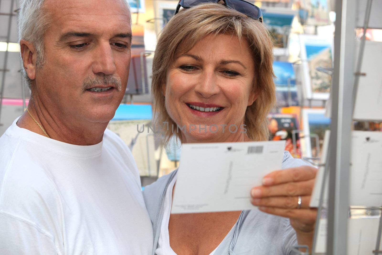 Couple buying post card by phovoir
