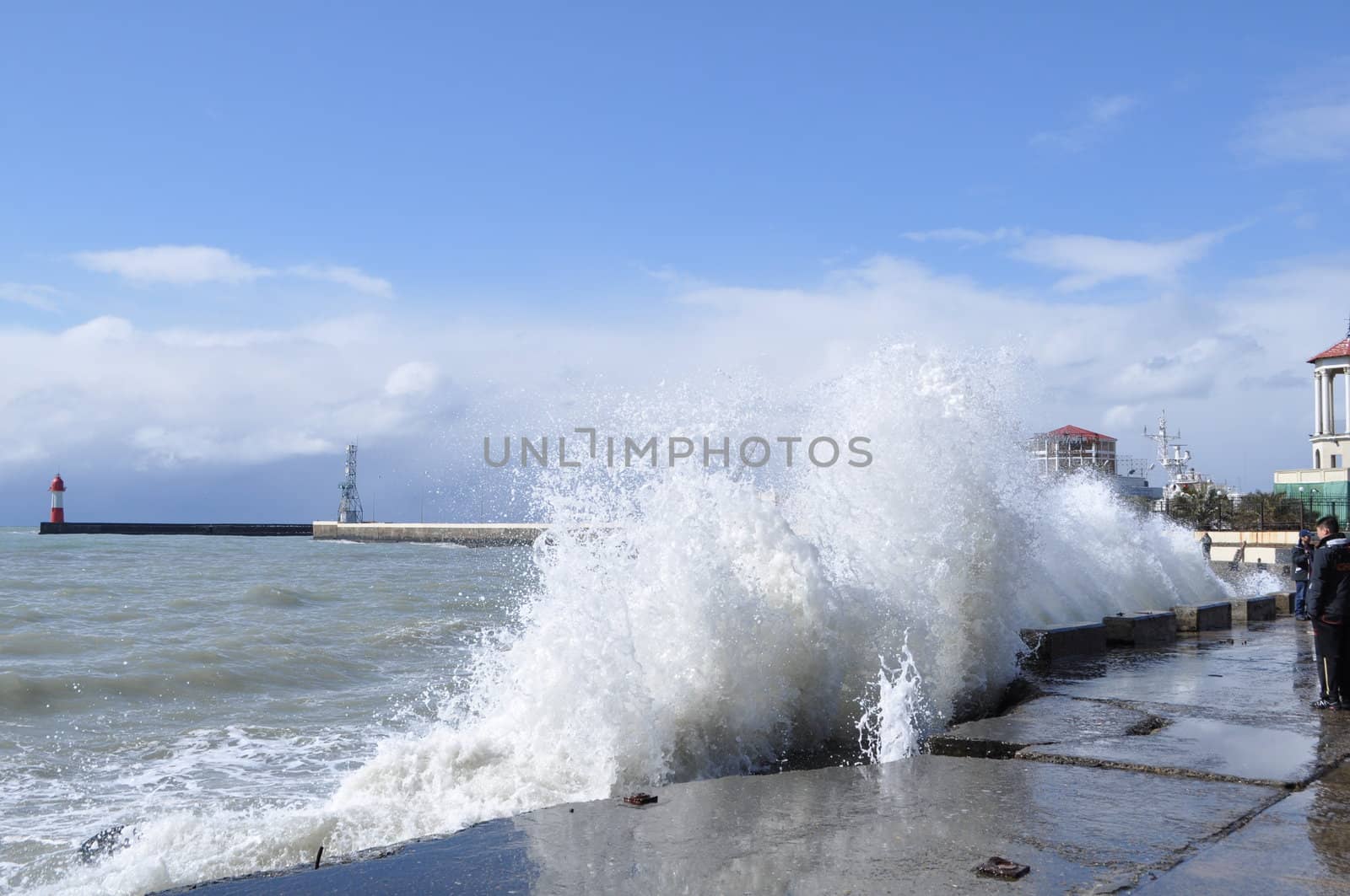 Sea waves breaking on concrete port with spray