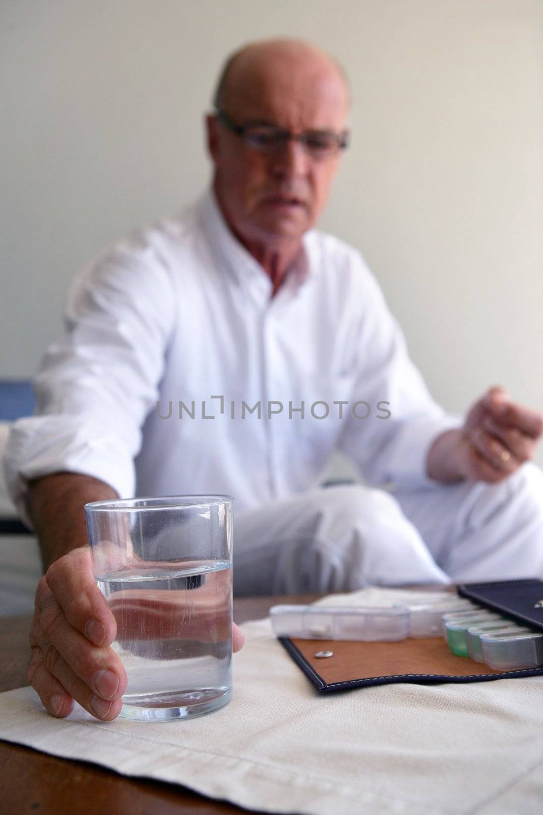 Senior man taking his medicine by phovoir