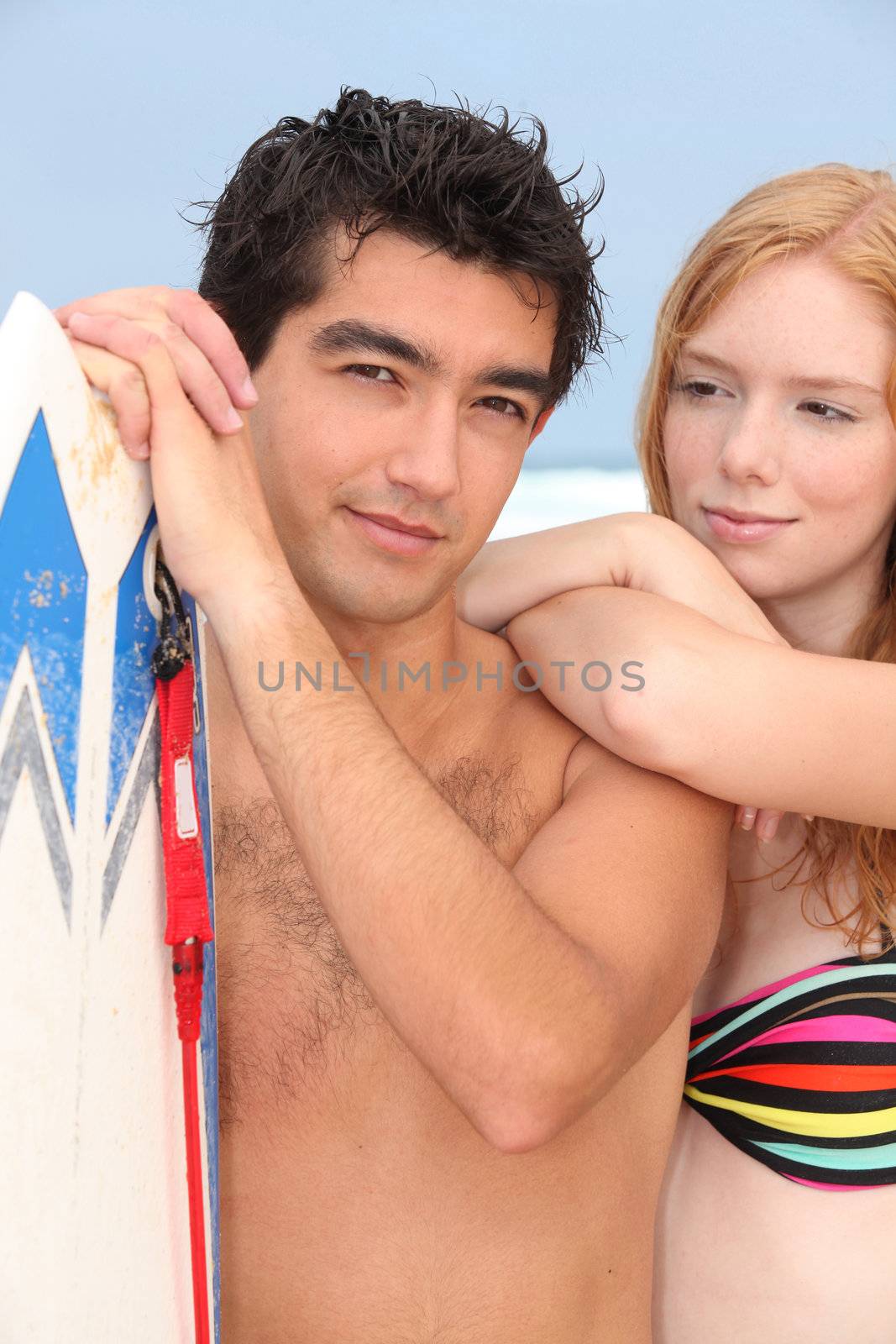 Young man and redhead with surfboard