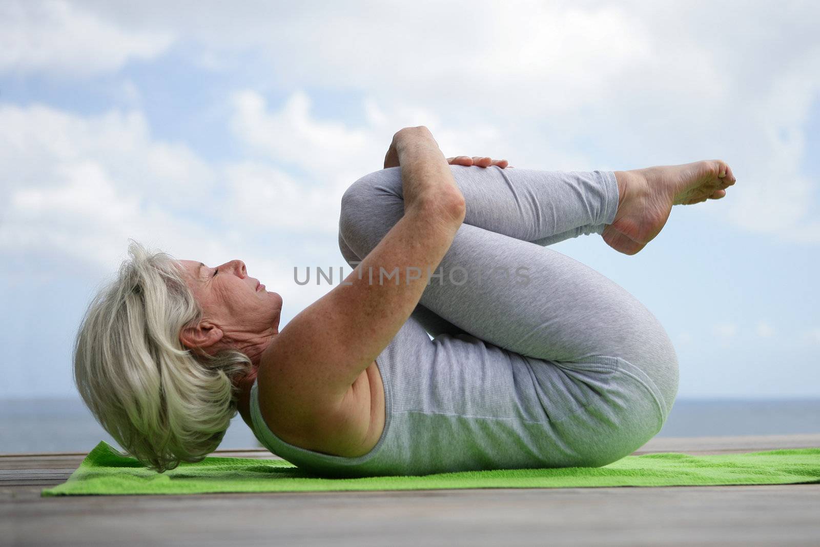 Woman practicing yoga by phovoir