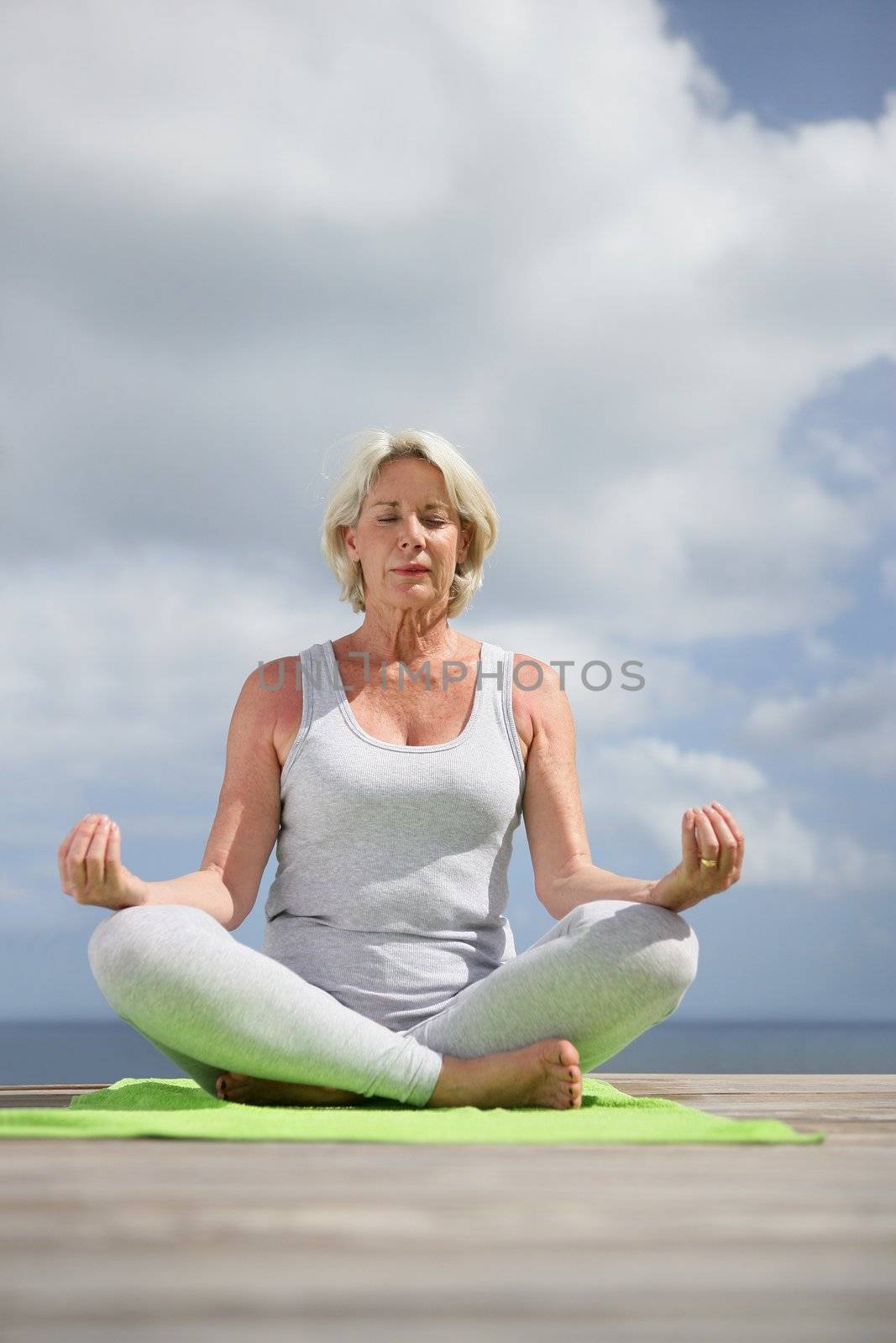 mature woman meditating by phovoir