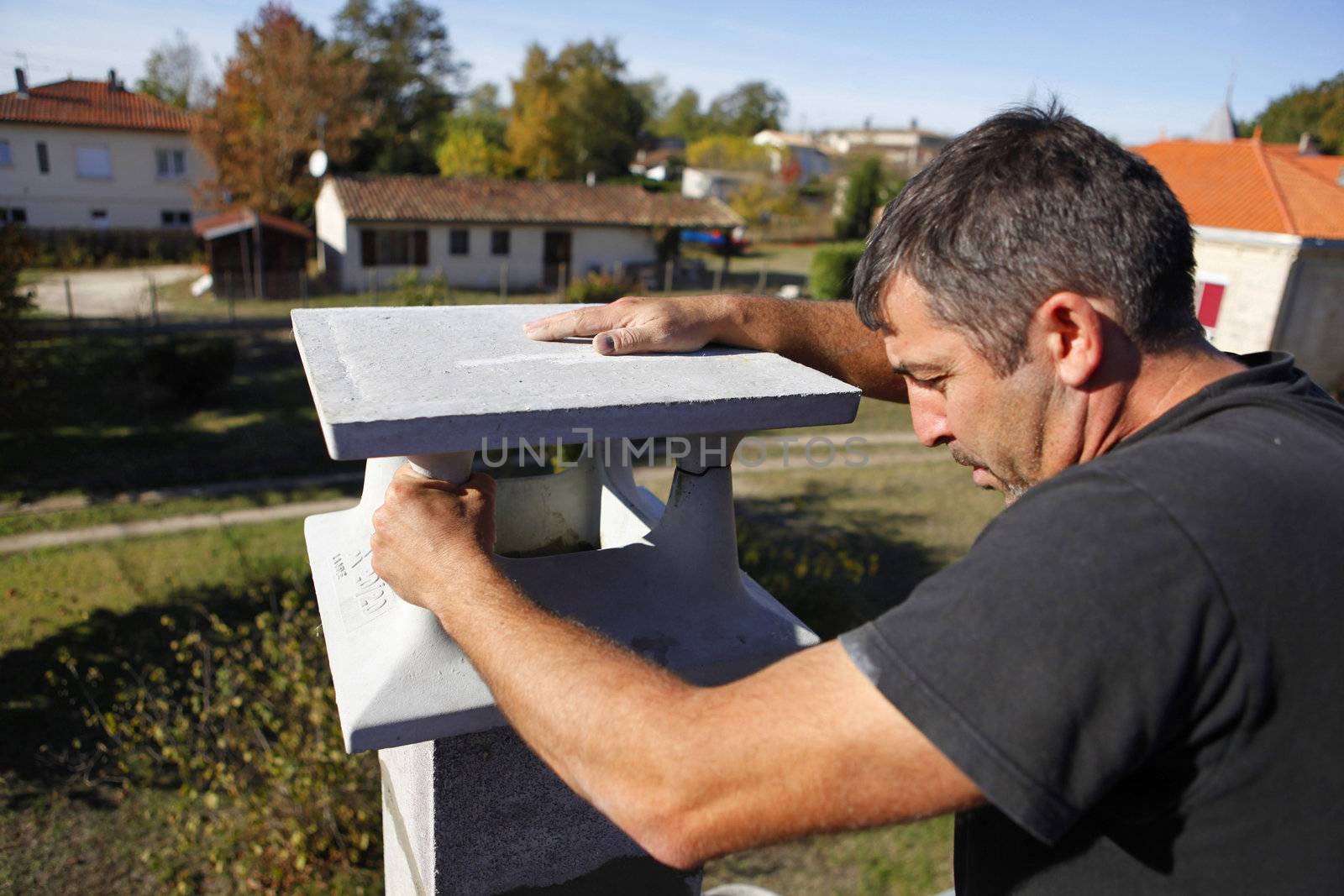 Builder finishing a gatepost by phovoir