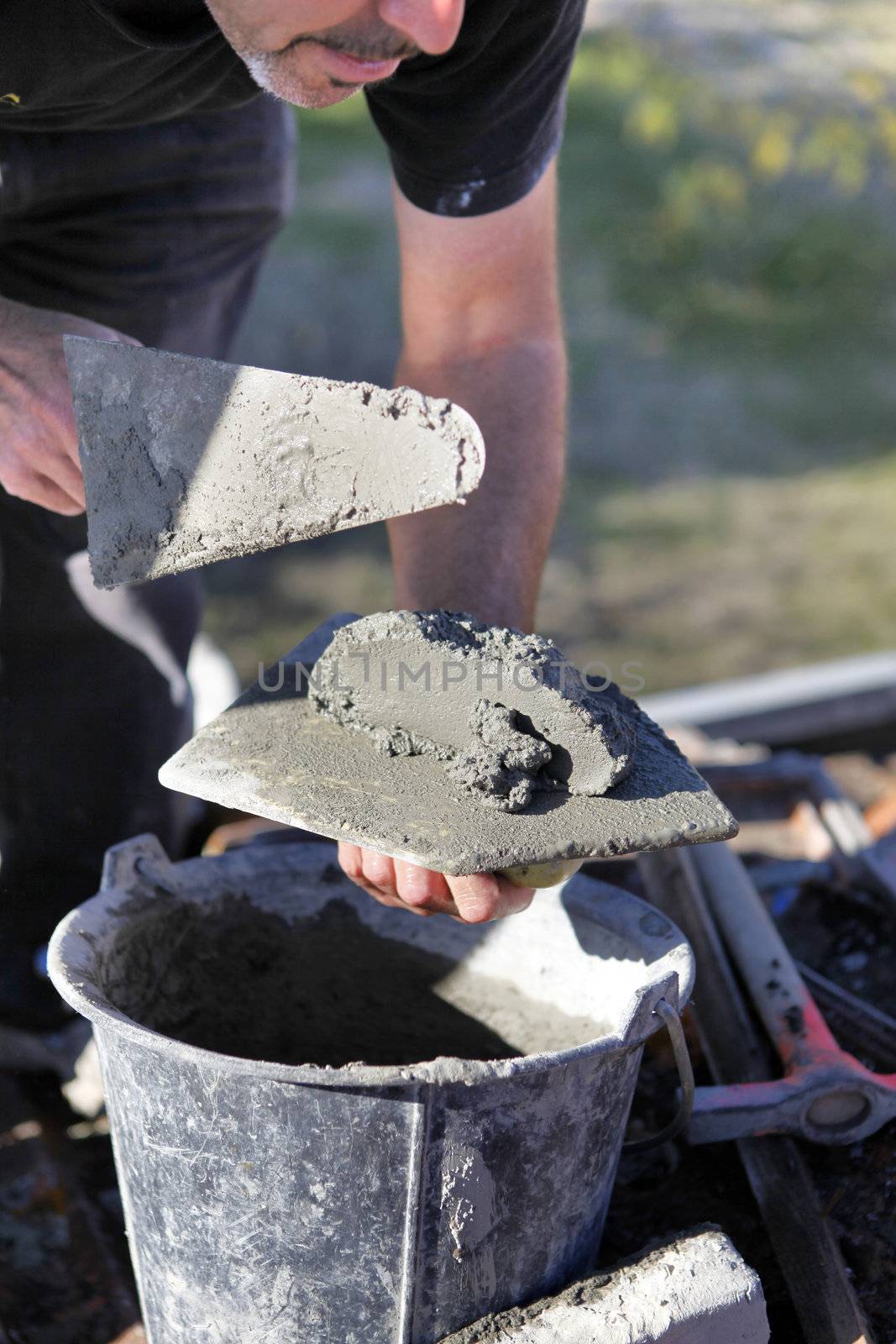 Man with cement and trowel by phovoir