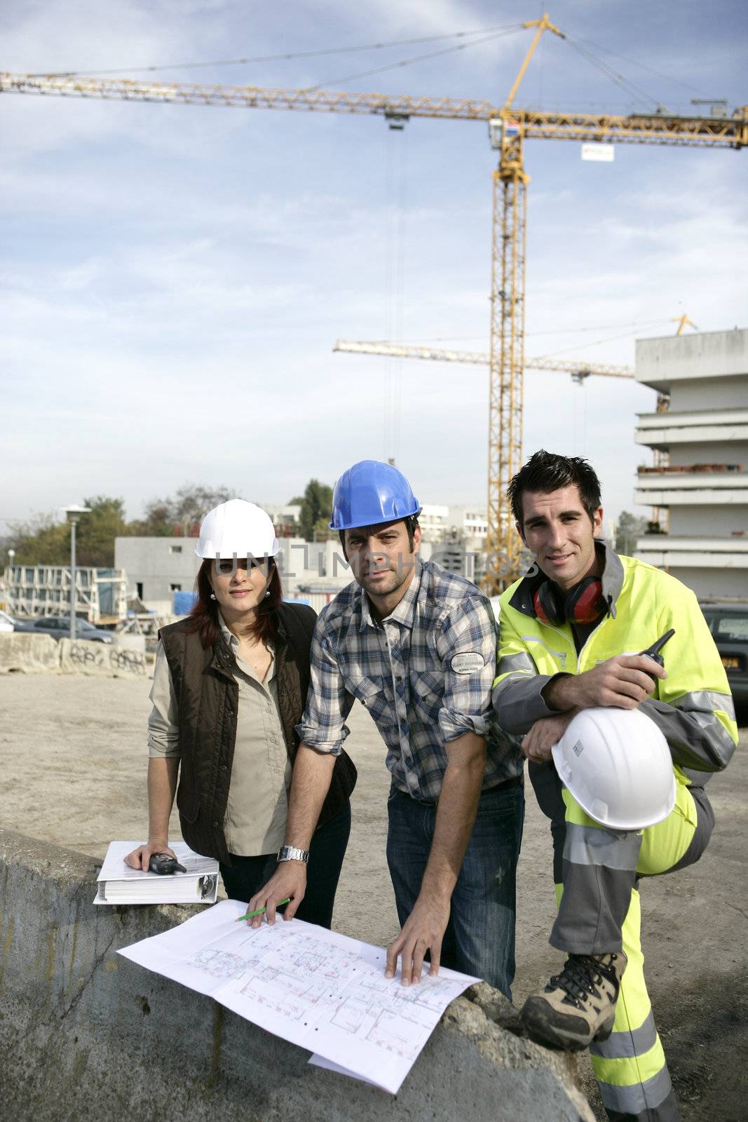 A team of construction workers working together by phovoir