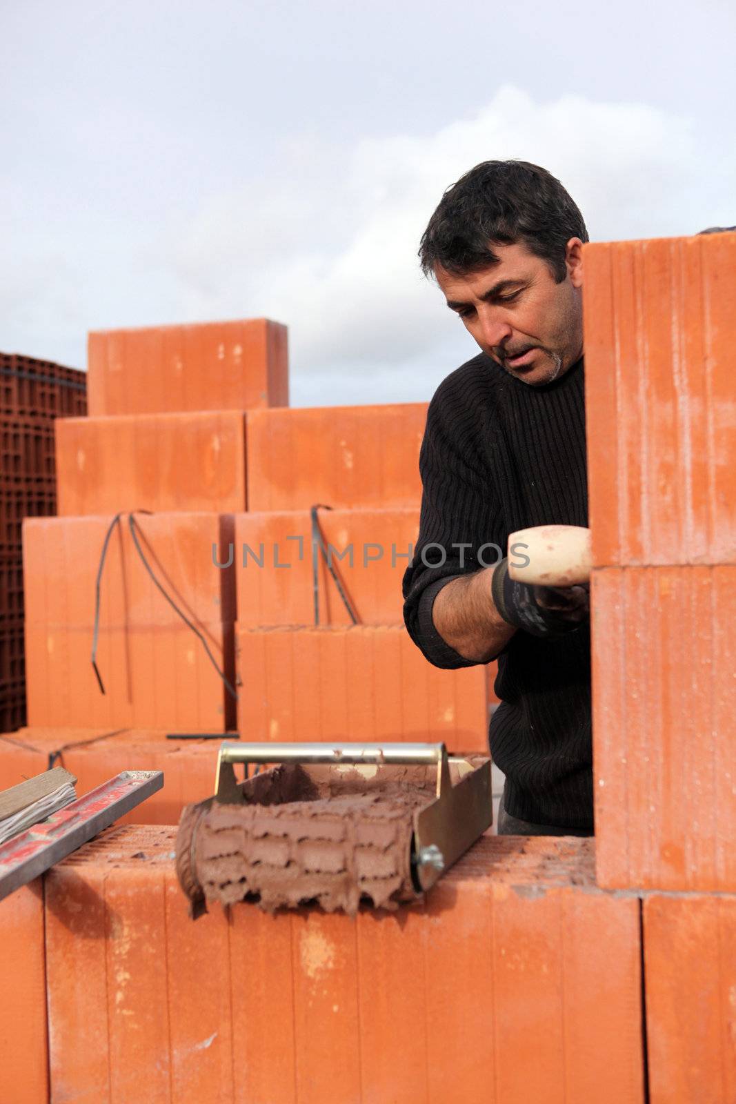 A bricklayer busy at work by phovoir