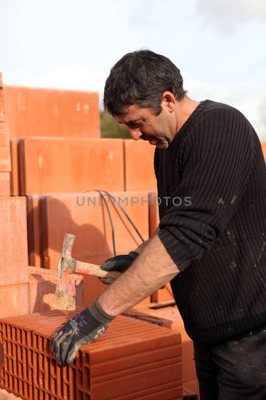 Builder shaping a brick