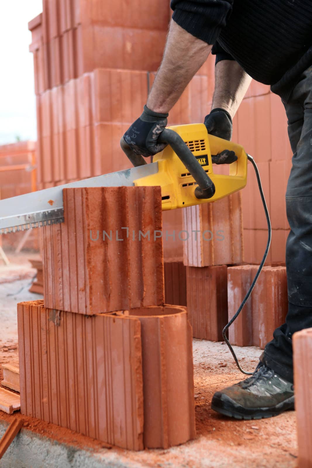 Builder cutting bricks to size