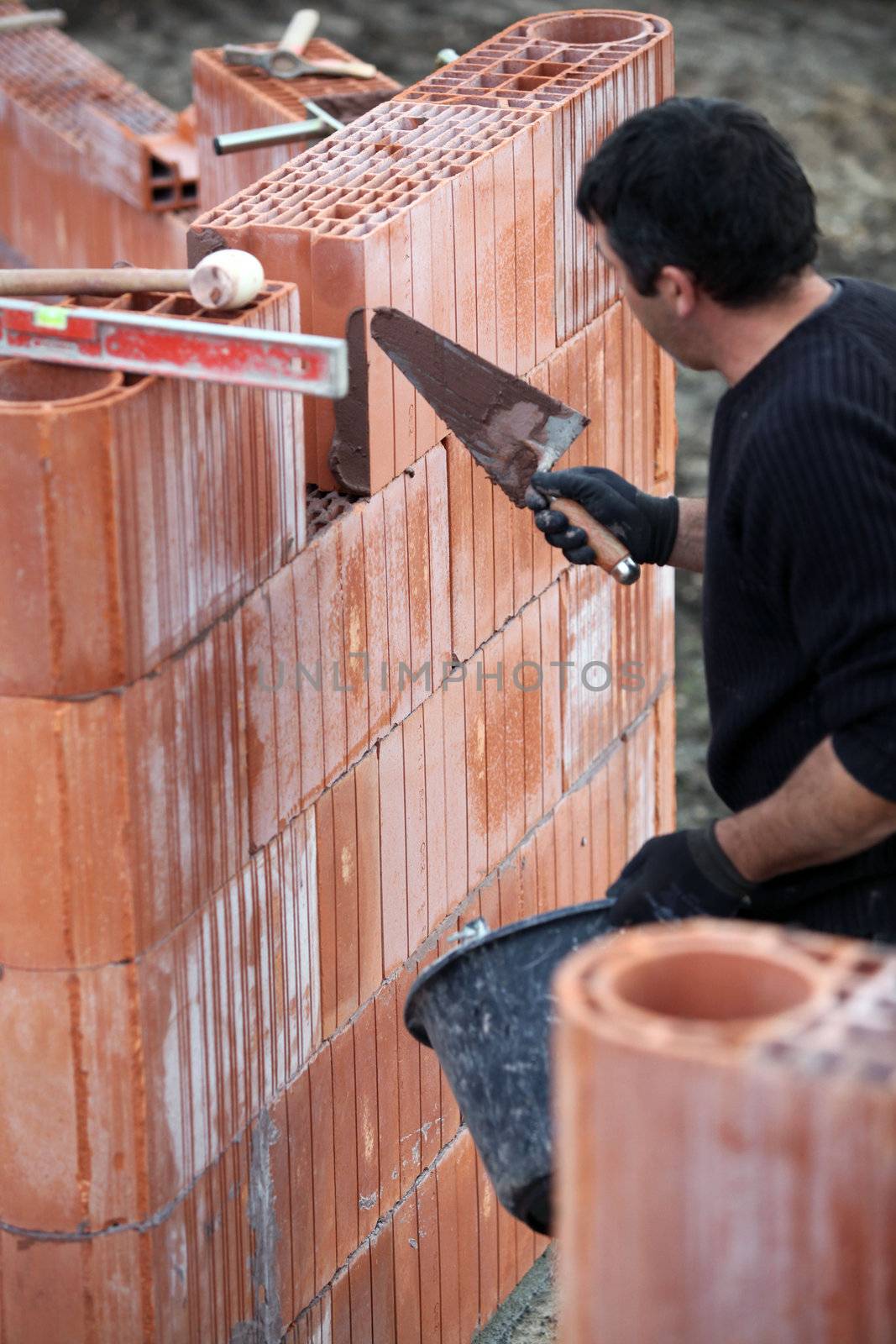Builder with a block wall by phovoir