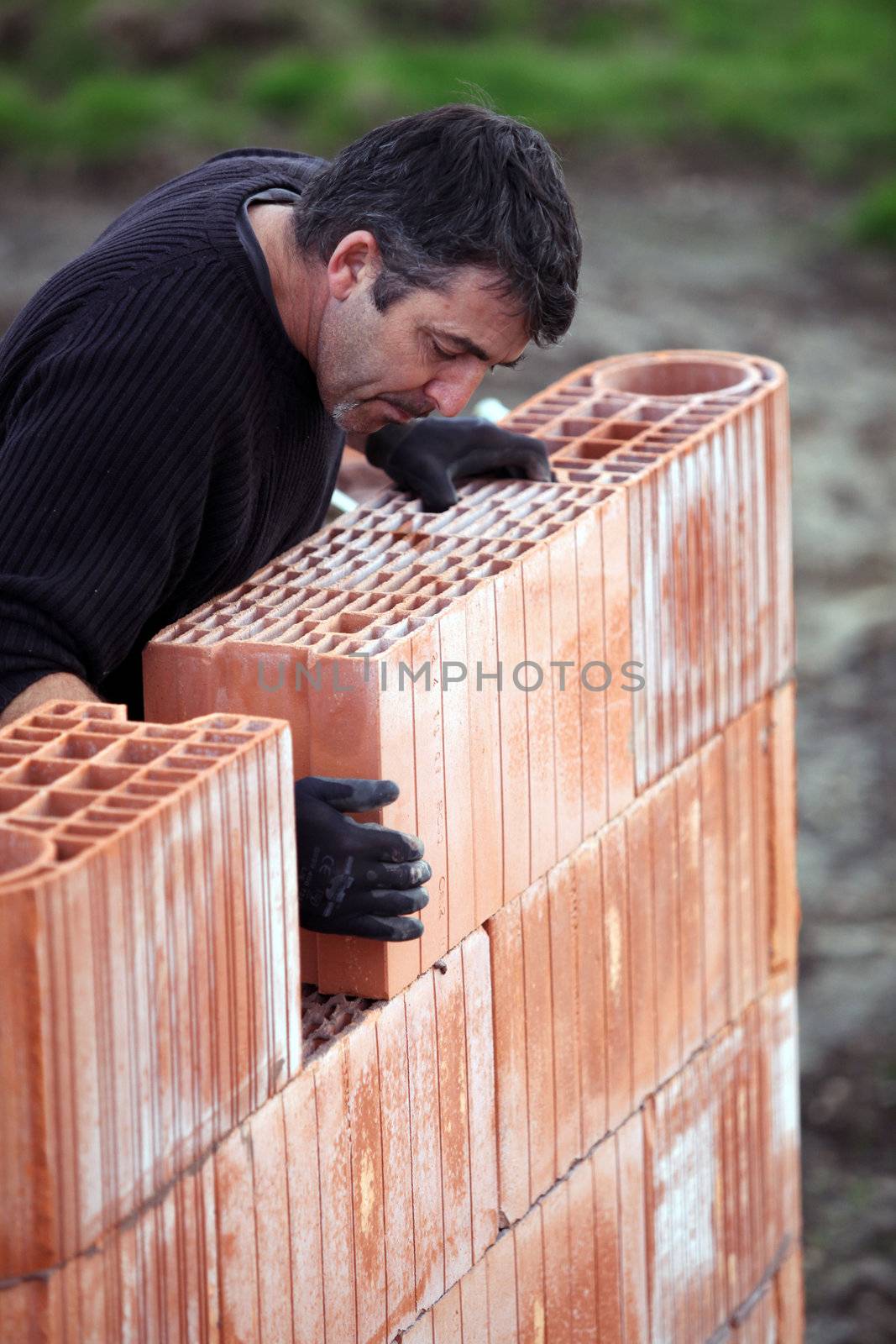 A tradesman laying a brick by phovoir