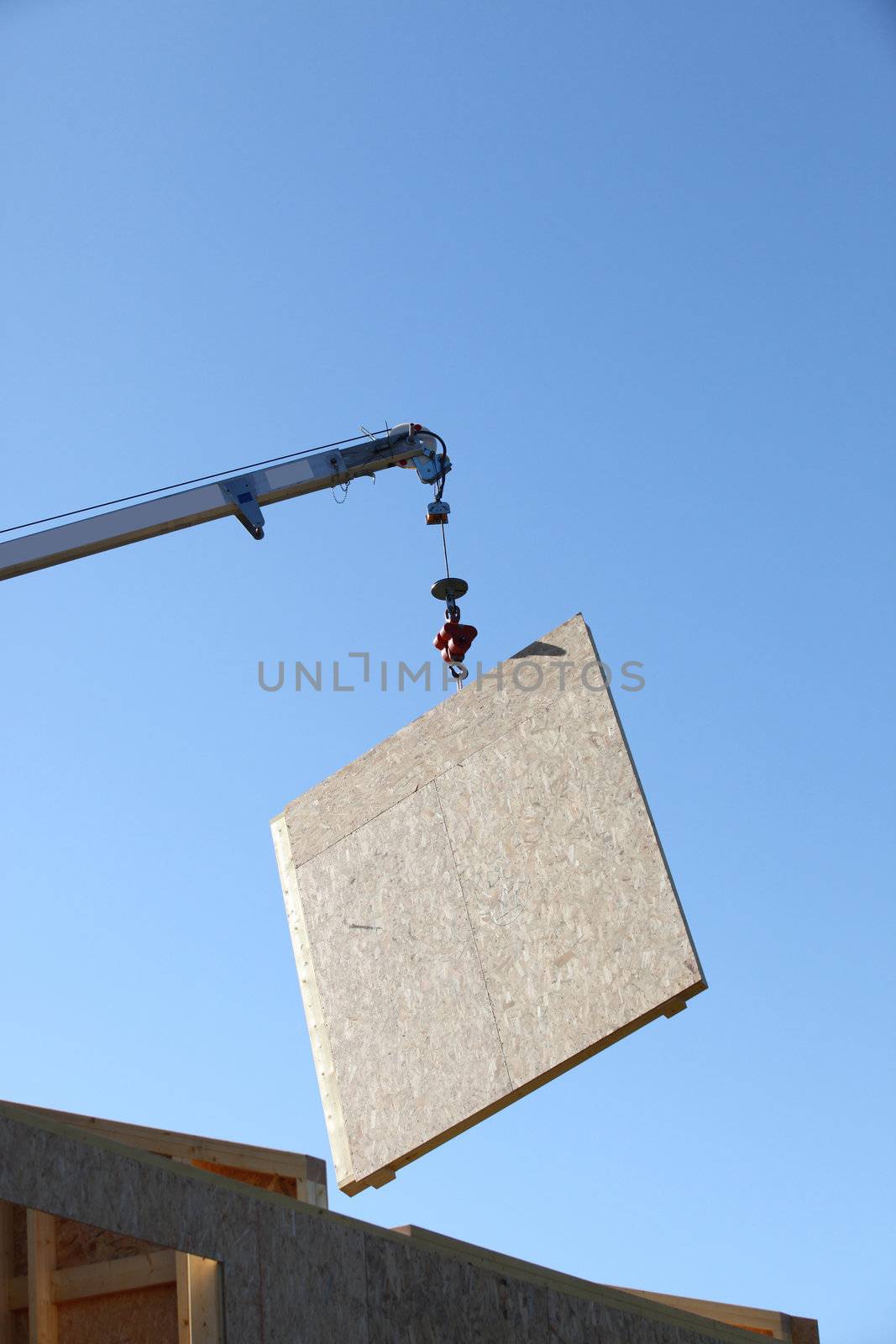 Wooden panel being lifted by crane