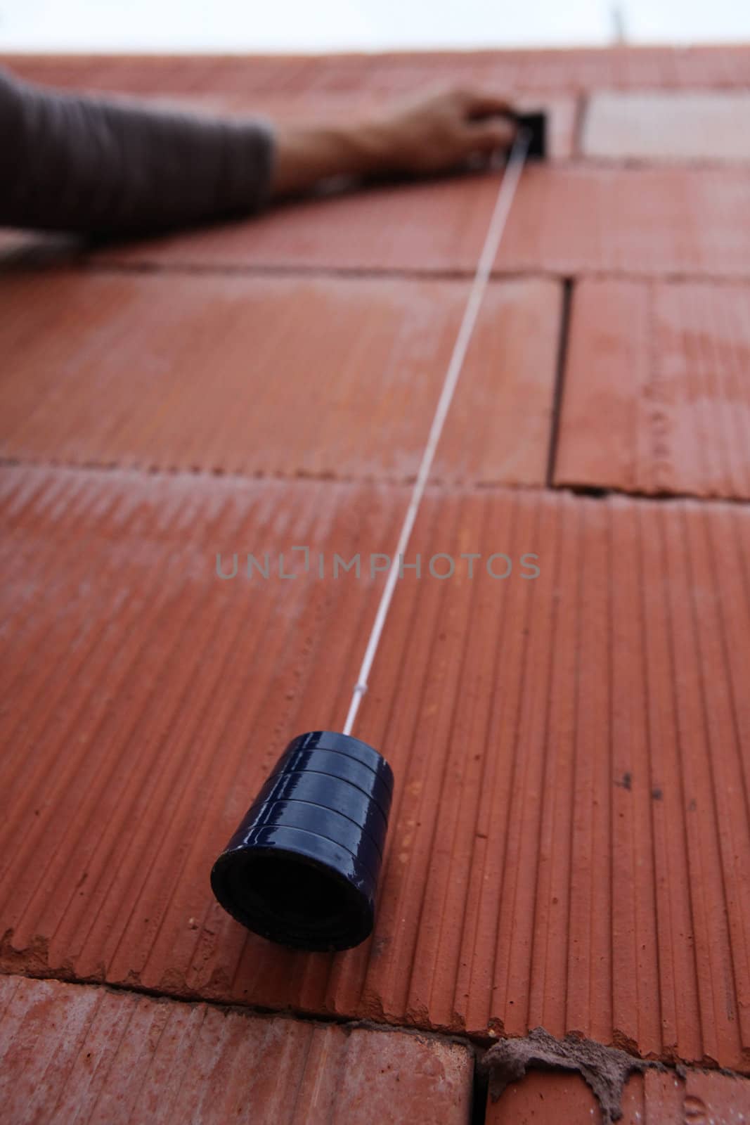 Bricklayer using a plumb line