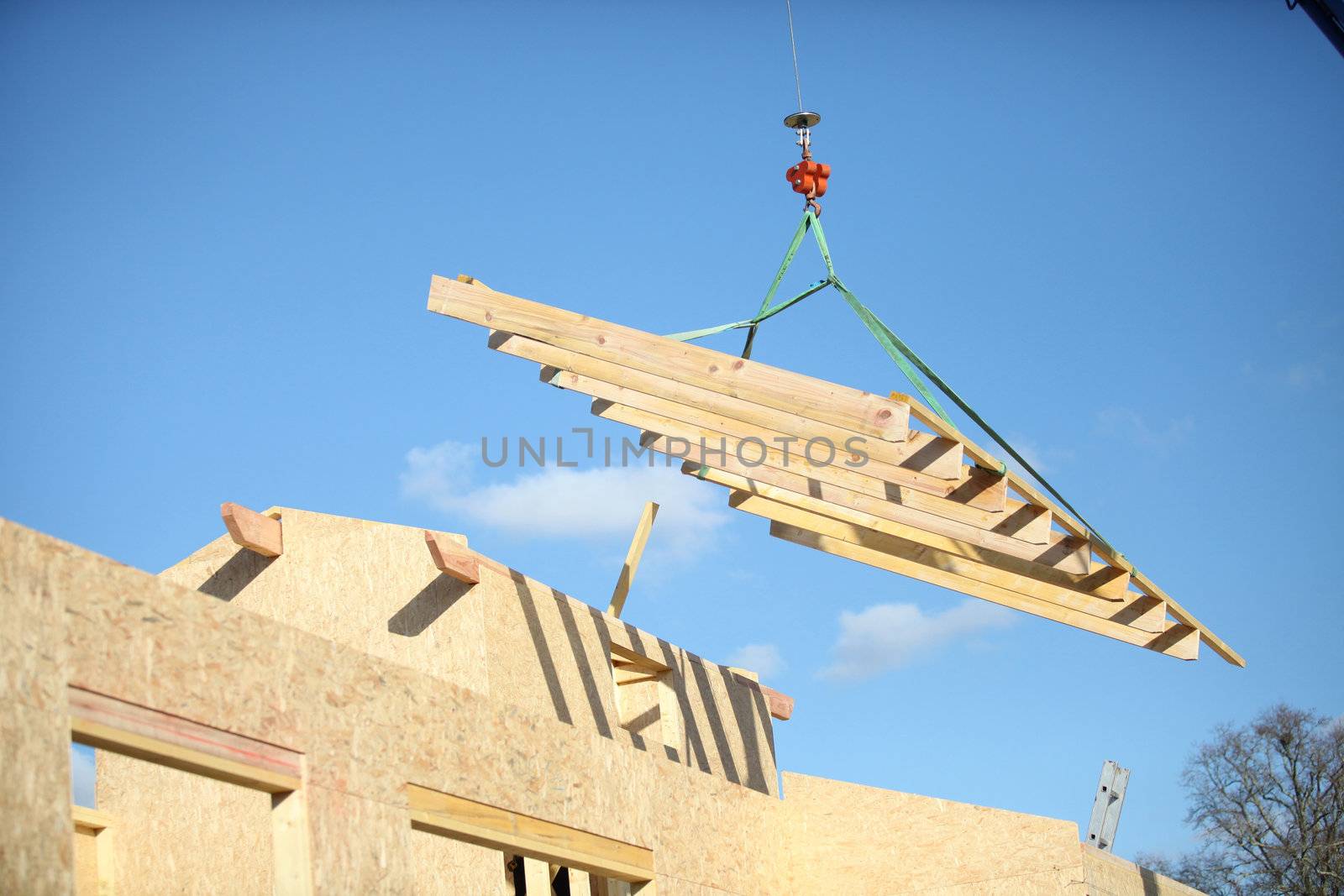 Crane lifting building materials by phovoir