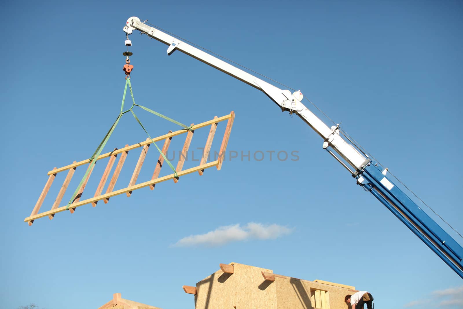 A crane lifting a wood structure. by phovoir