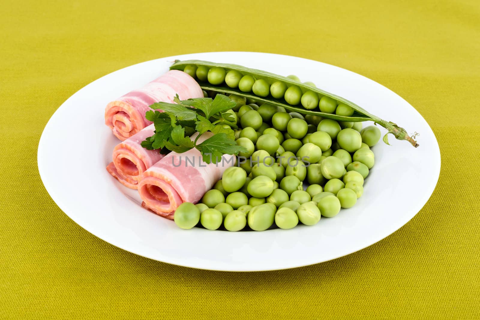Fresh peas and ham rolls isolsted on background.