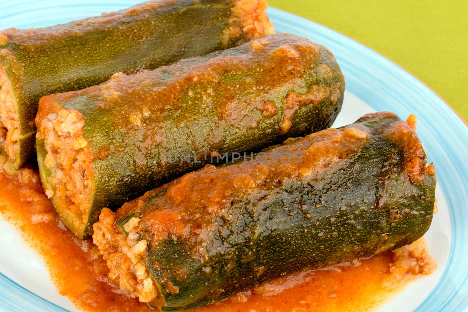 Three pieces of zucchini stuffed with rice and meat.