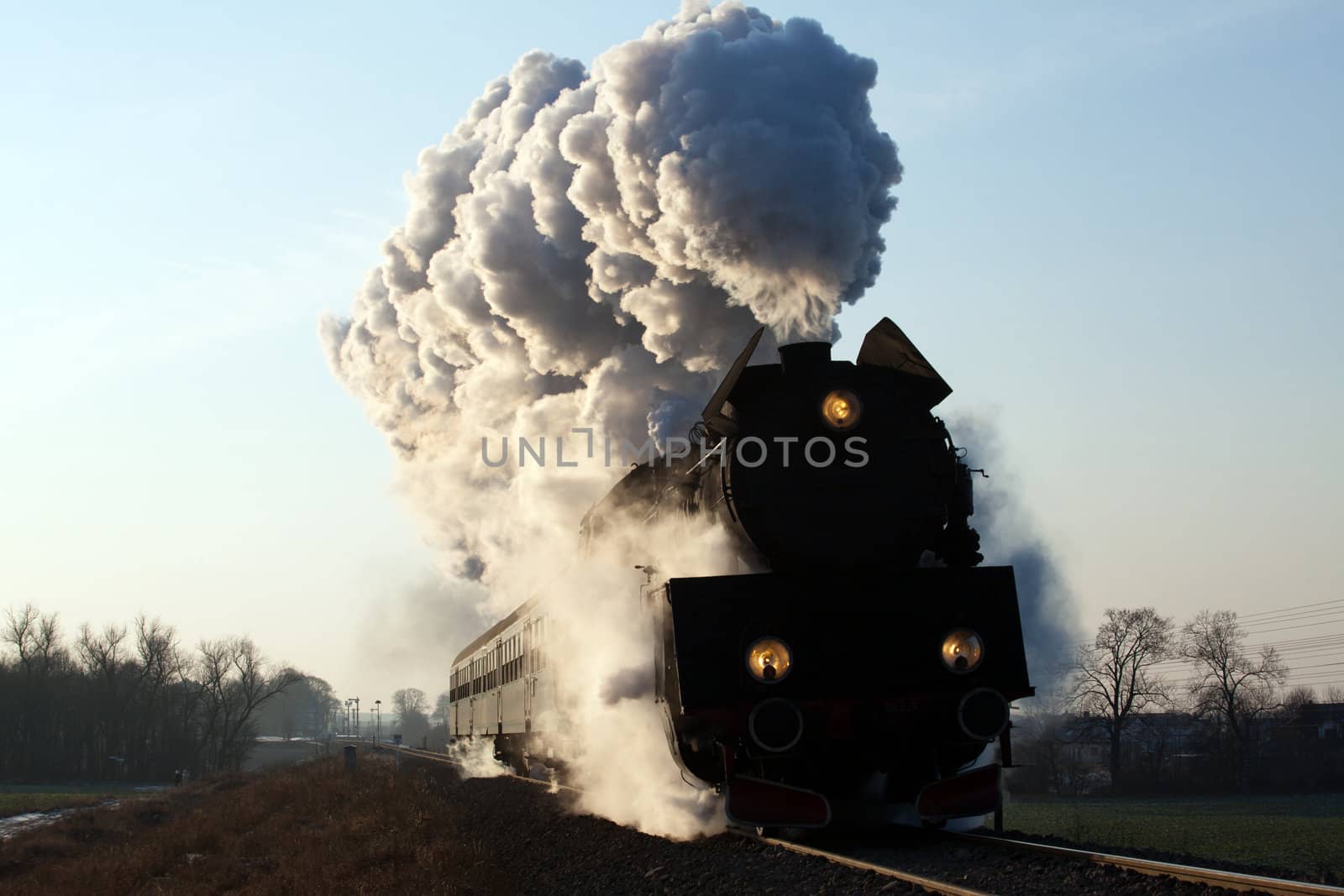 Vintage steam train starting from the station, wintertime

