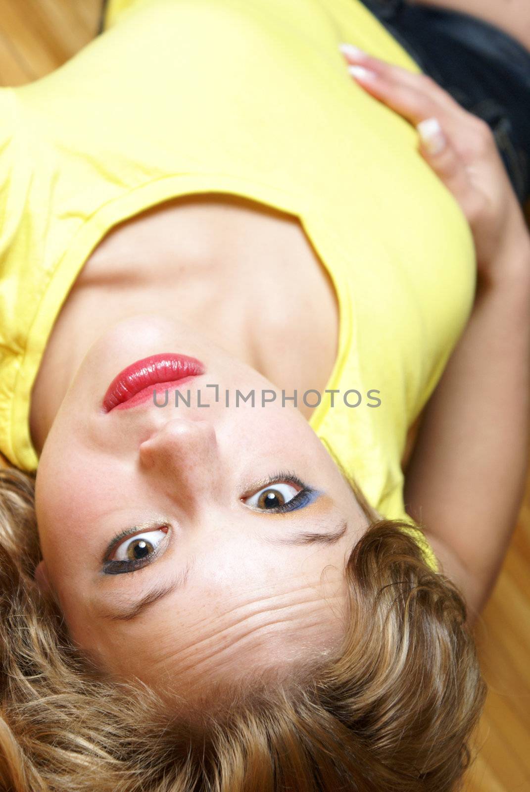 An attractive woman lays on her back while on the floor.