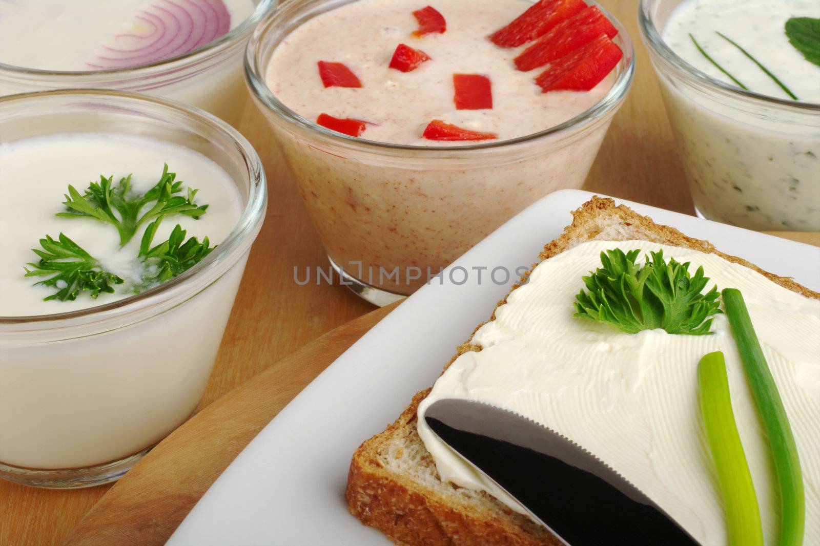 Bread on plate with cream cheese and various spreads in the background (Selective Focus)