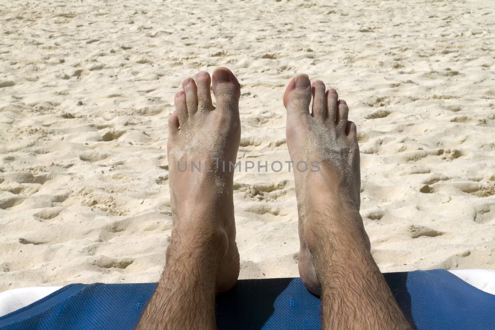 Two feet relaxing on a beach by the ocean