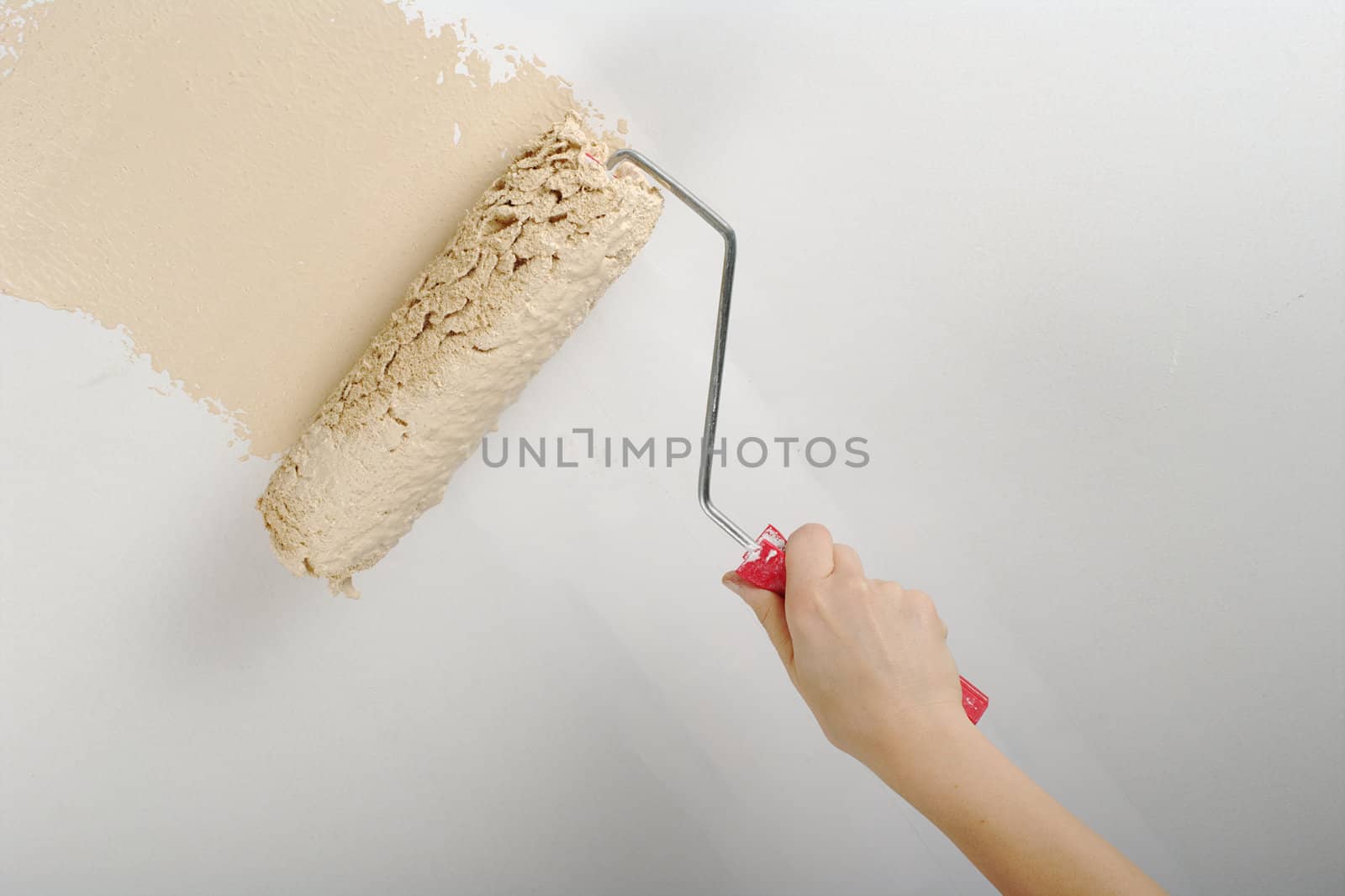 Hand painting with roller on white wall