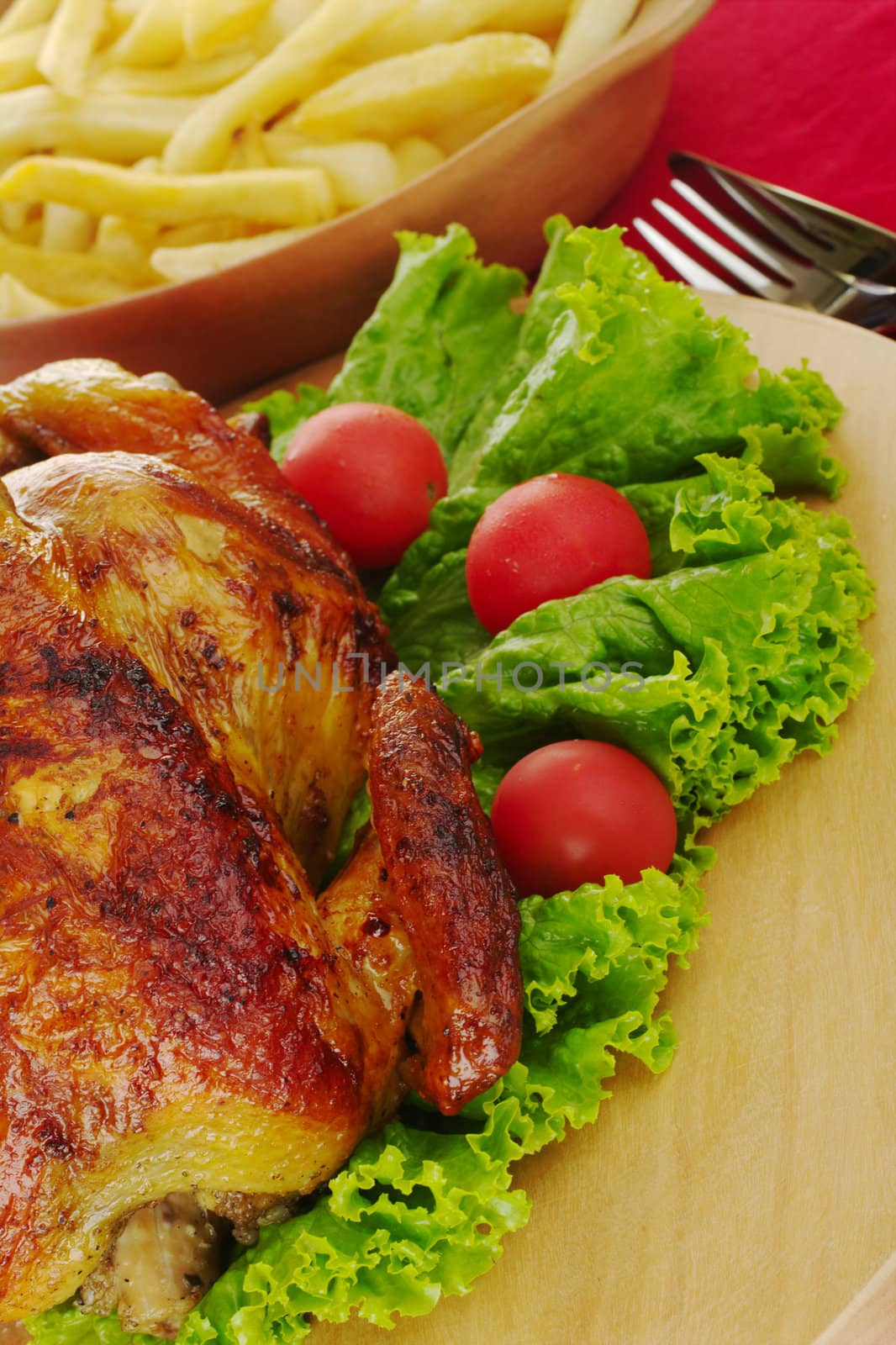 Grilled chicken with lettuce, cherry tomatoes, french fries and cutlery (Selective Focus) 