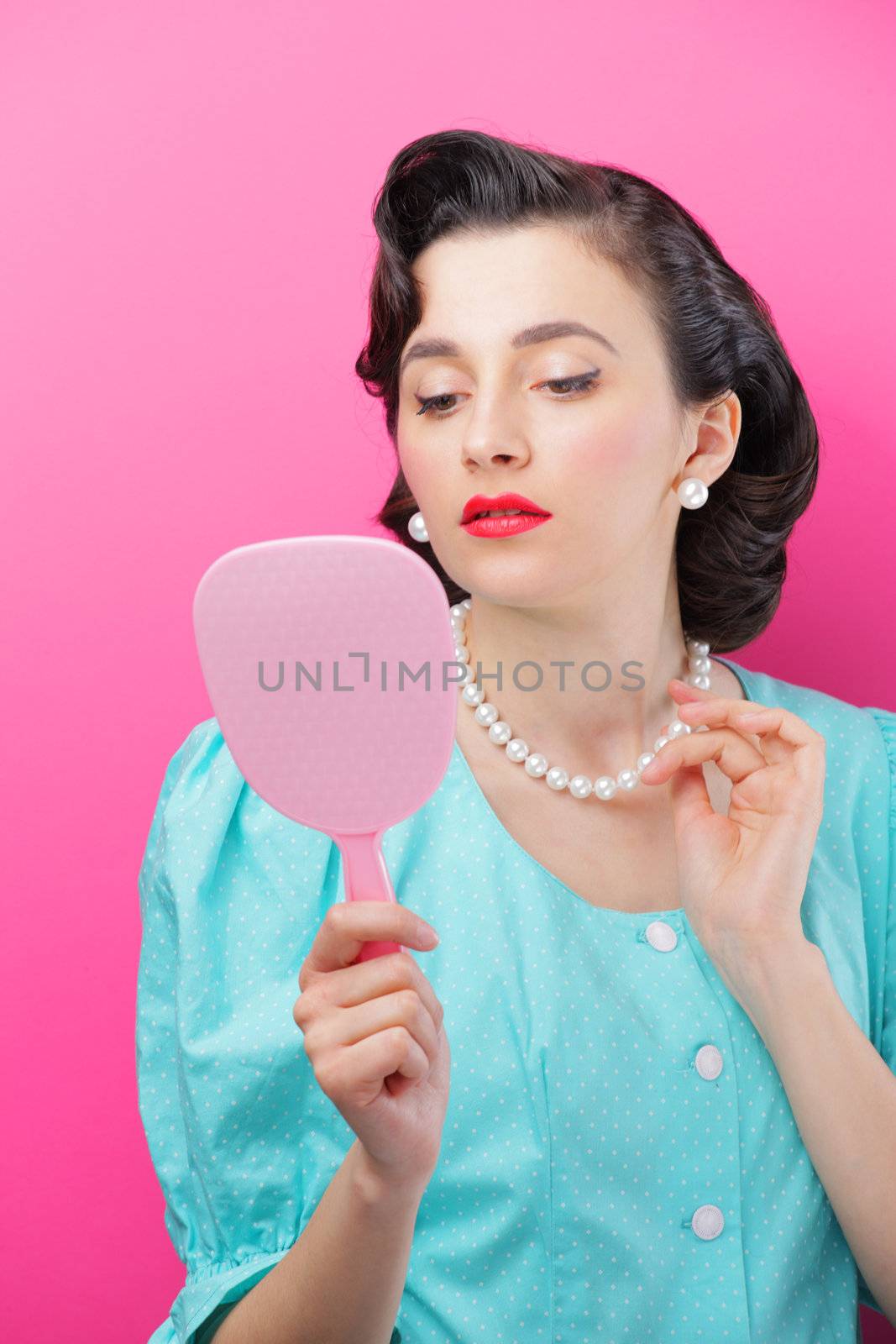 Young woman looking at her face in the mirror.