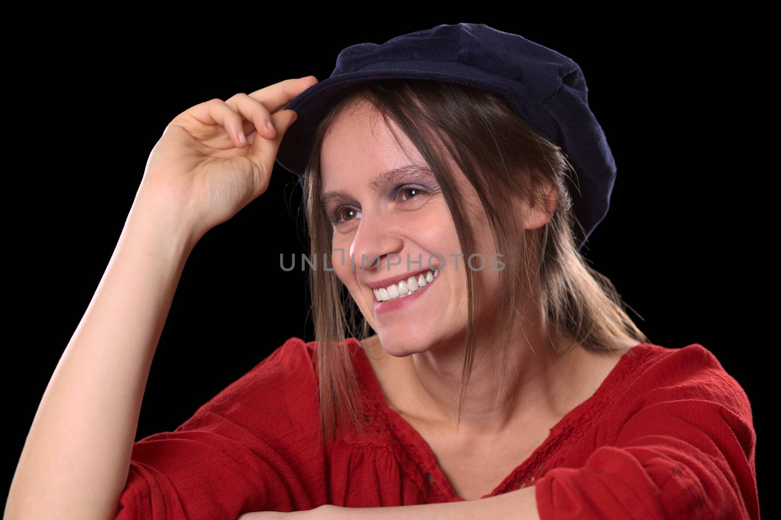Portrait of a young Caucasian woman smiling wearing a red shirt and a blue Gatsby cap (Selective Focus, Focus on the left eye and the left side of the face)
