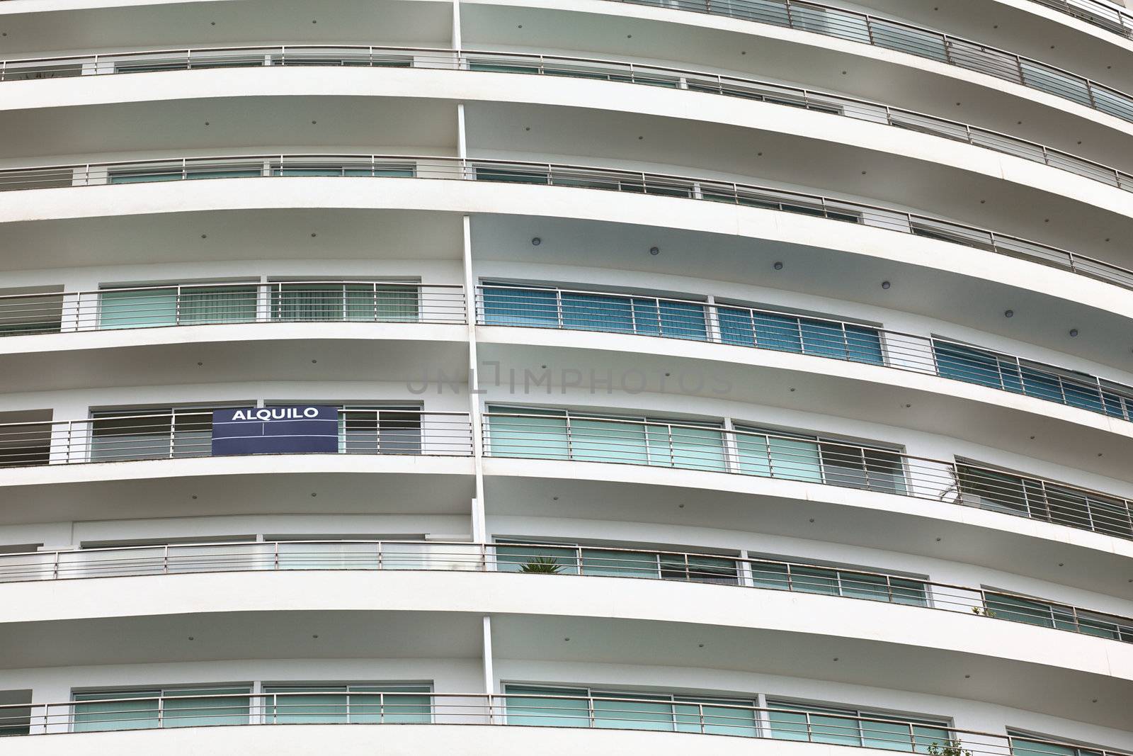 Detail of a modern multi-storey apartment building with balconies (alquilo means for rent)